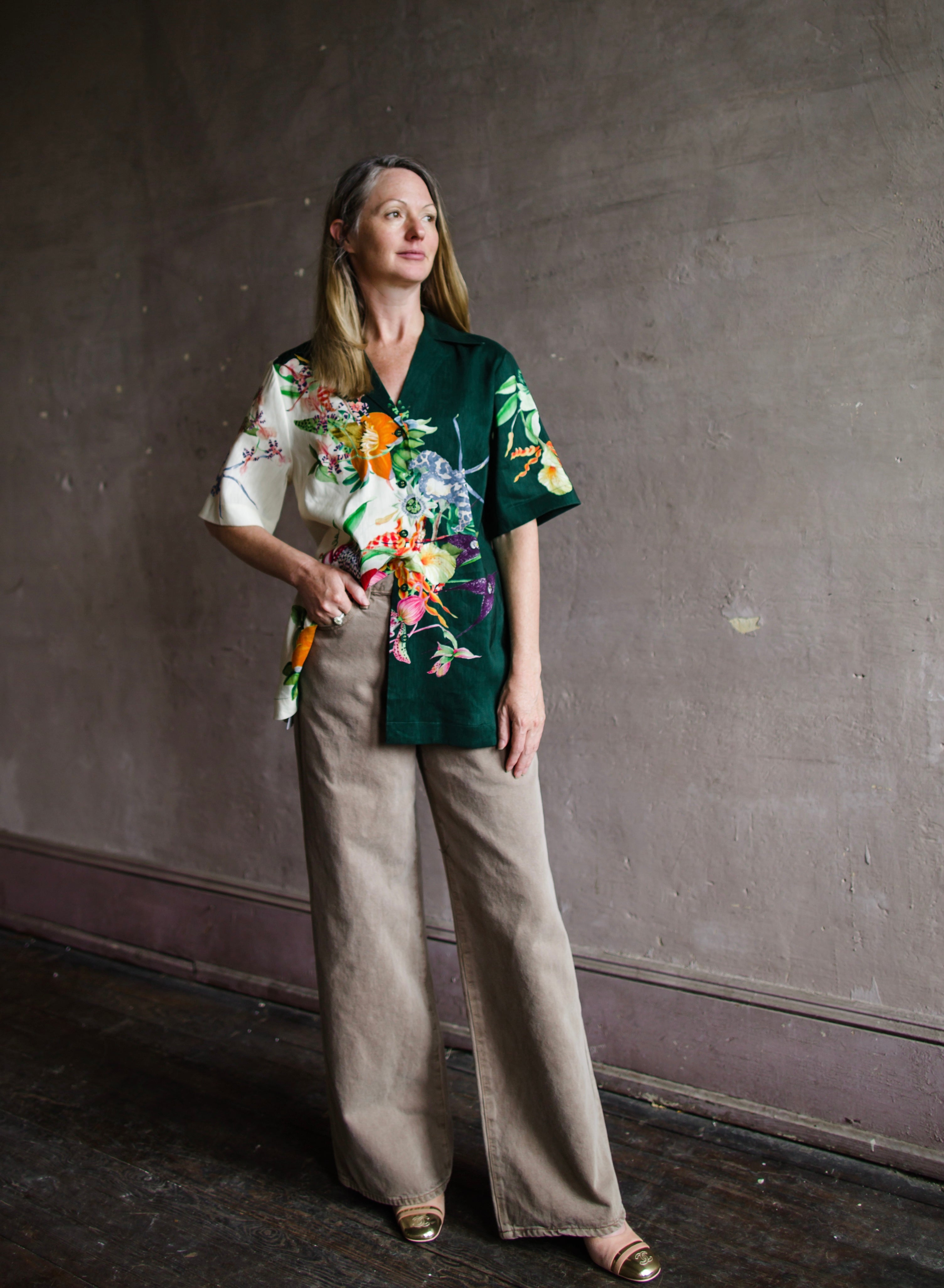 Image featuring a woman wearing the linen blend Aggie top by Alemais with a button front and boxy fit and an allover tropical floral print in green multi-color.