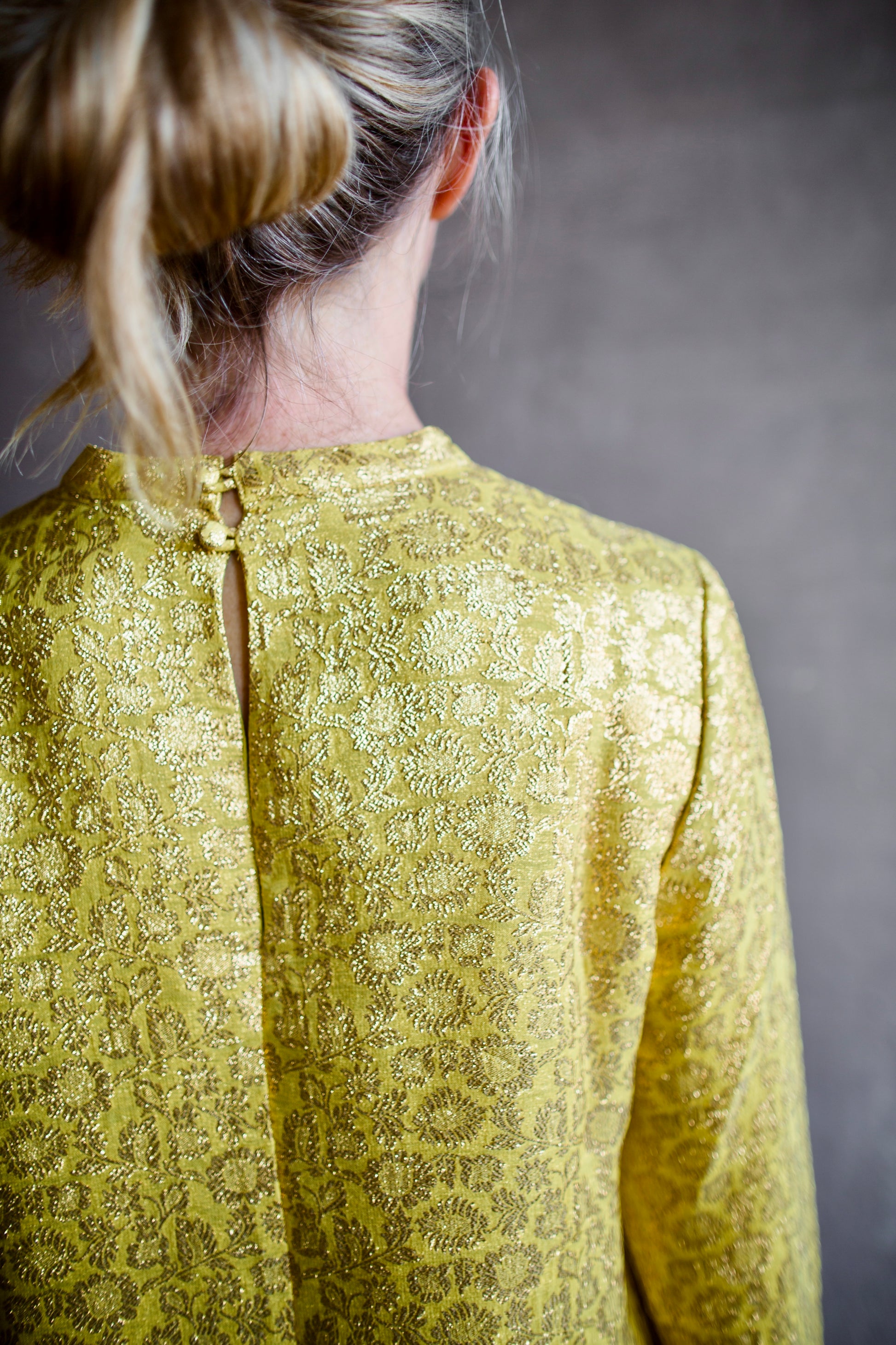 Image featuring a woman wearing the yellow Astra top by Alemais features a crew neckline with brocade texture and beaded fringe trim.