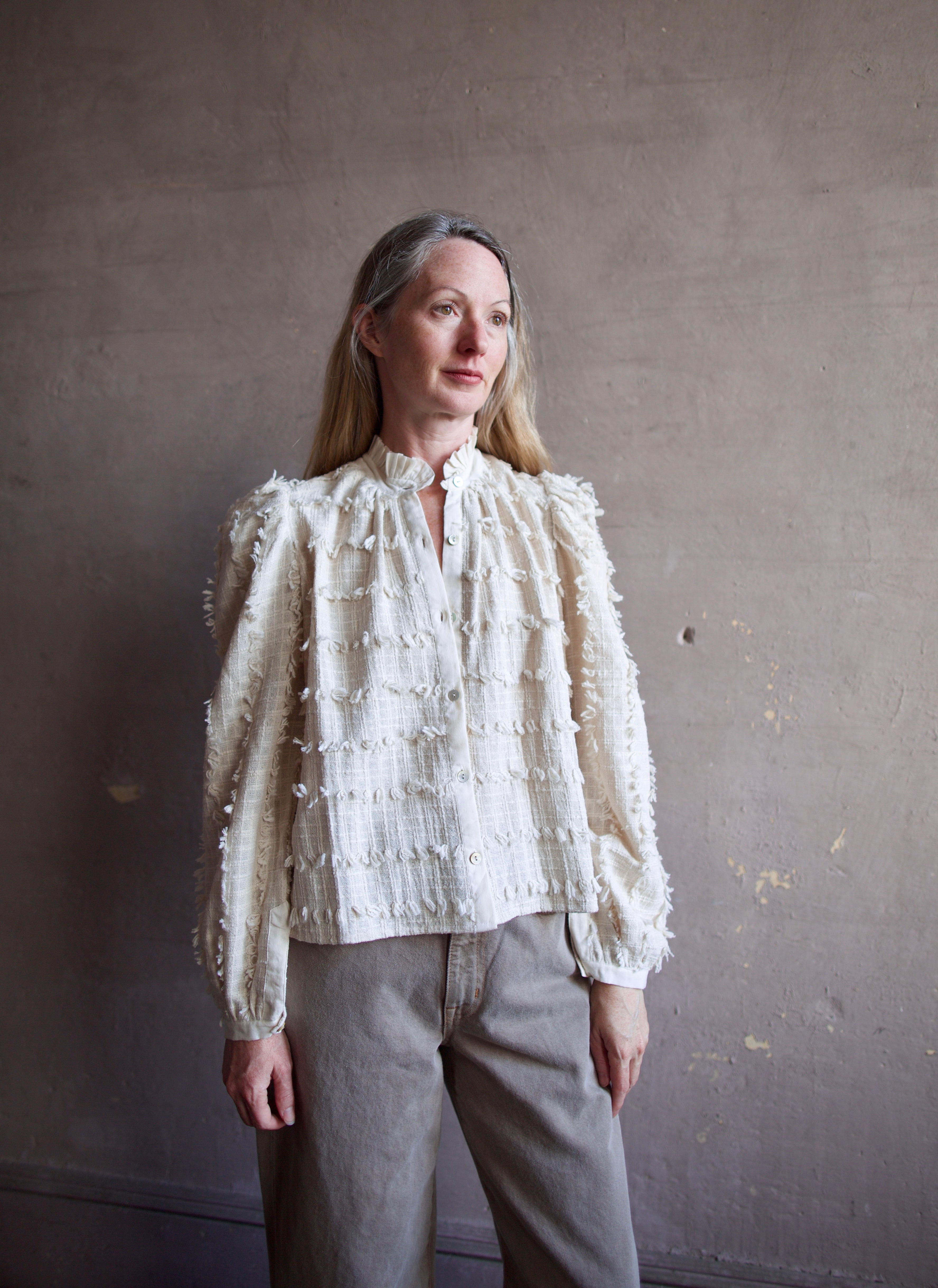 Image featuring a woman wearing the Alix of Bohemia Ana Snow Feather Shirt with a button front,  puff sleeves, a boxy fit and intricate texture throughout.