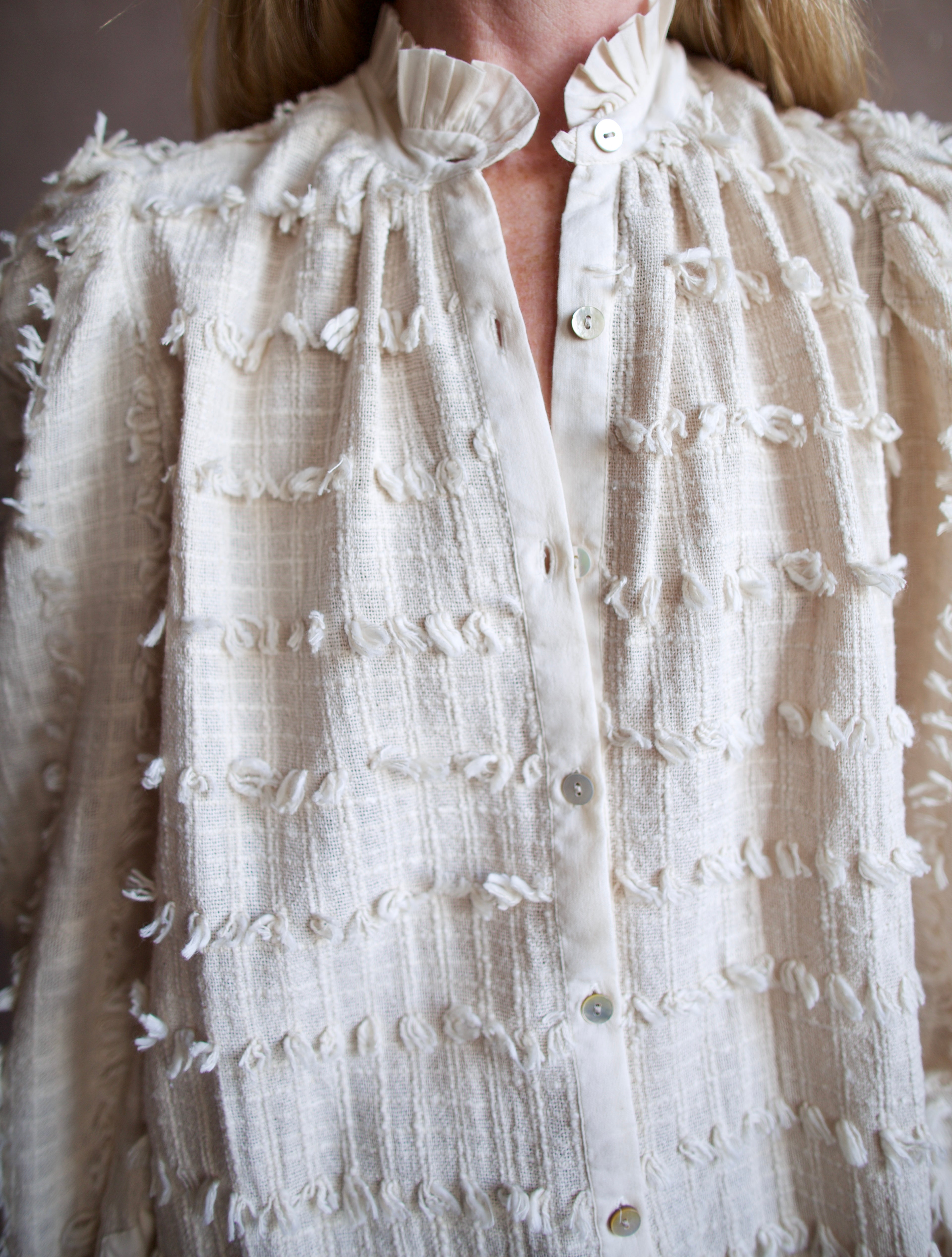 Image featuring a woman wearing the Alix of Bohemia Ana Snow Feather Shirt with a button front,  puff sleeves, a boxy fit and intricate texture throughout.