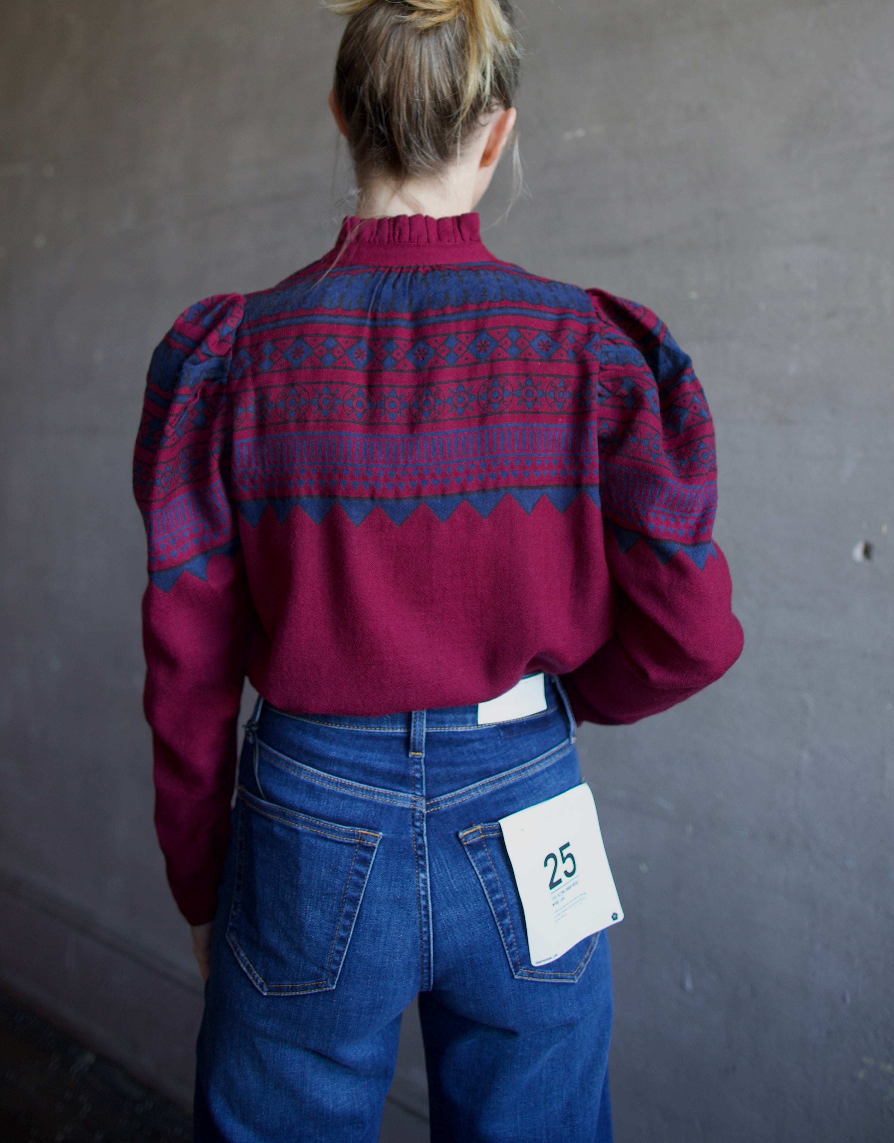 Image featuring behind view of a woman wearing The Alix of Bohemia Artemis Plum Fairisle top which features a button front with puff sleeves and a slightly boxy fit.
Color: Plum
Fabrication: 100% Wool
Fits True to size