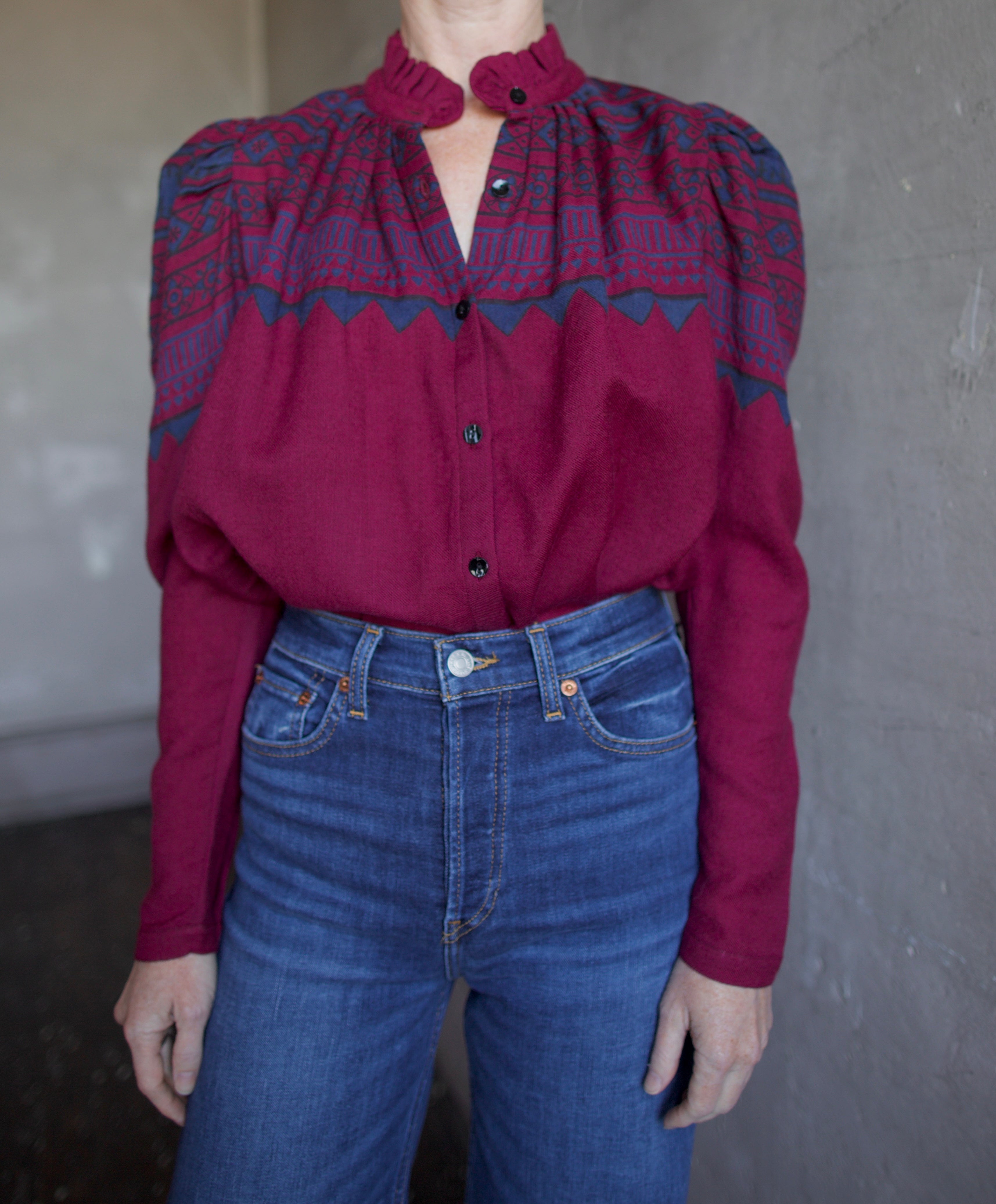 Image featuring a woman wearing The Alix of Bohemia Artemis Plum Fairisle top which features a button front with puff sleeves and a slightly boxy fit.
Color: Plum
Fabrication: 100% Wool
Fits True to size