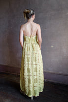 Image featuring a woman wearing the Autumn Embroidered dress by Alix of Bohemia with spaghetti straps that lace up the back, a tailored bodice and allover embroidery in yellow.