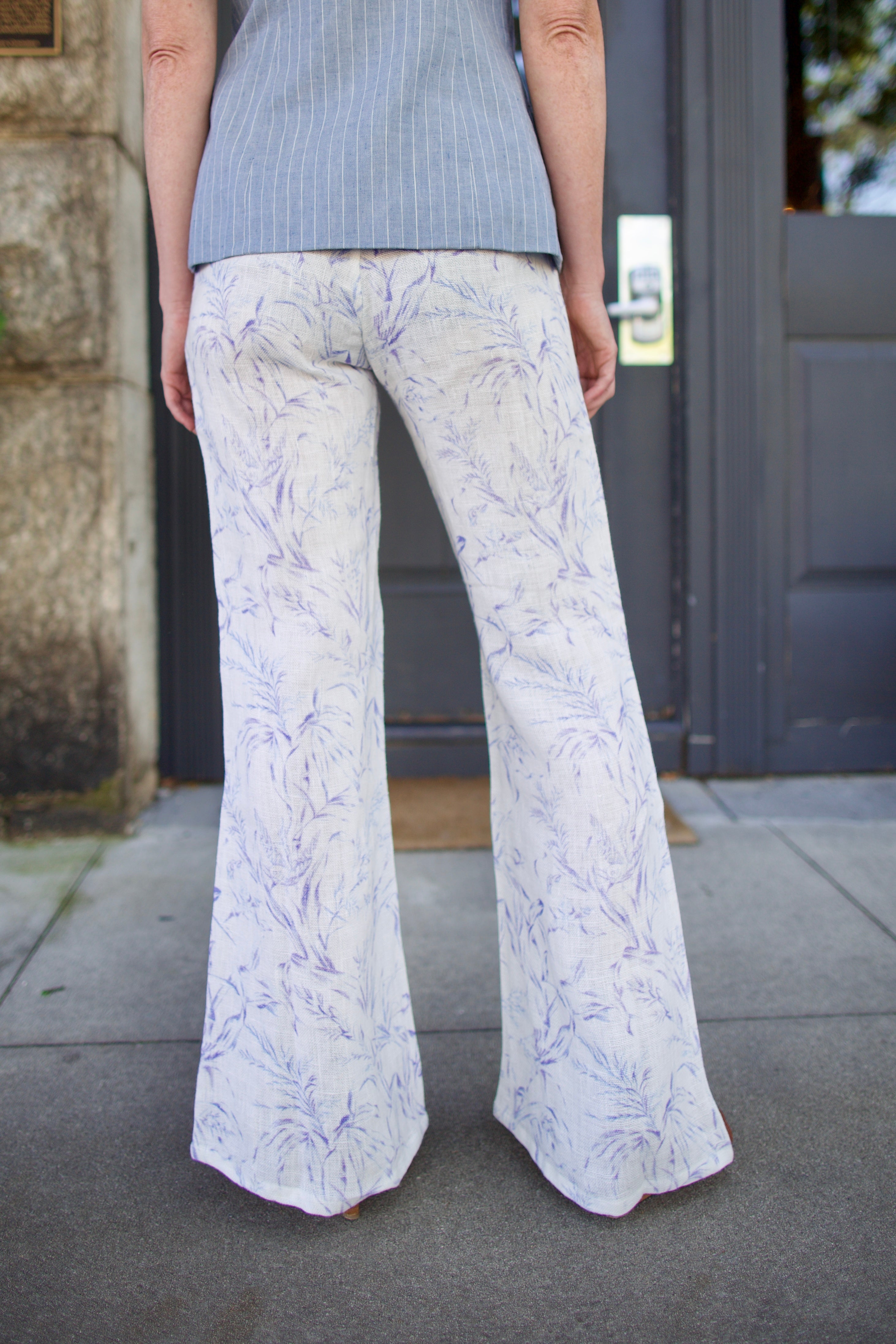 Model wearing luxury designer Alix of Bohemia bunny toile linen trousers in white avian colorway