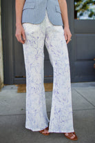 Woman wearing luxury designer Alix of Bohemia bunny toile linen trousers in white with blue print flare high rise