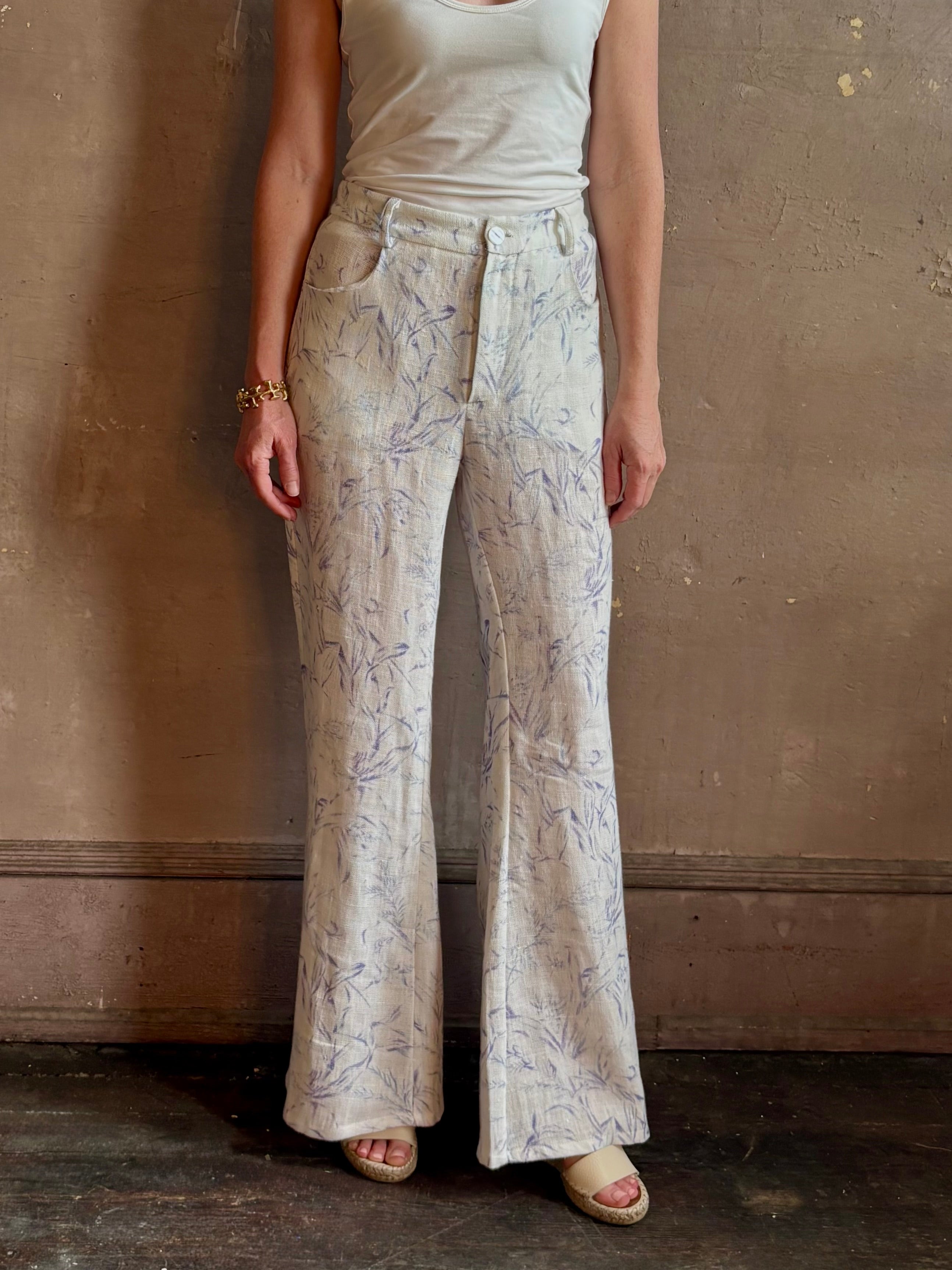 Woman wearing luxury designer Alix of Bohemia bunny toile linen trousers in white with blue print flare high rise