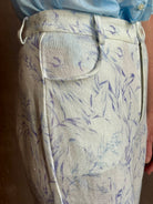 Woman wearing luxury designer Alix of Bohemia bunny toile lightweight linen trousers in white with blue print 