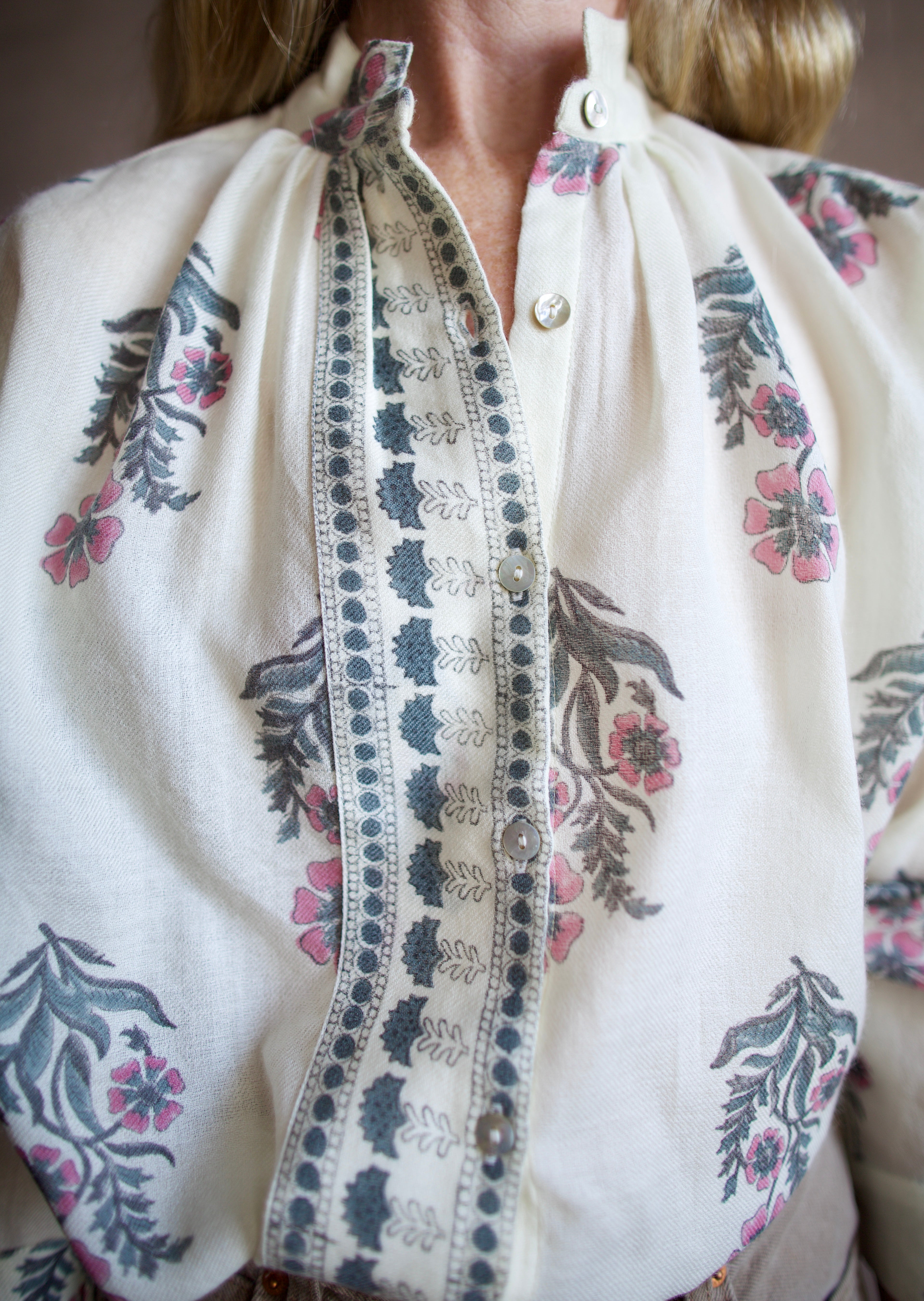 Image featuring a woman wearing the Alix of Bohemia Kiki Mirabillis top with a button front, full sleeve and a blue & pink floral block print on a white wool shirt.