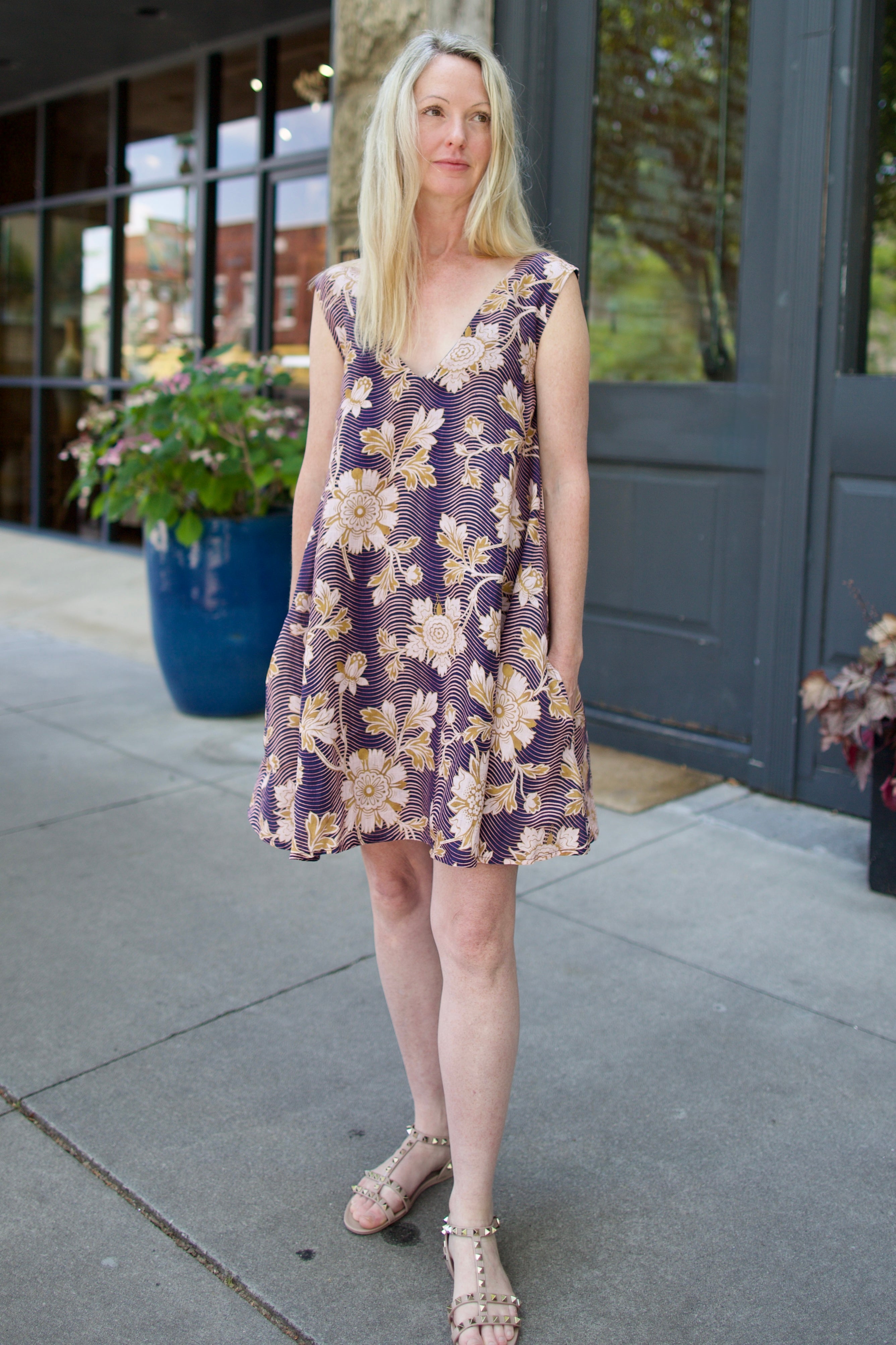 Model wearing a navy linen floral dress by high- end designer Alix of Bohemia Soleil Way Zinnia with v-neck and pockets