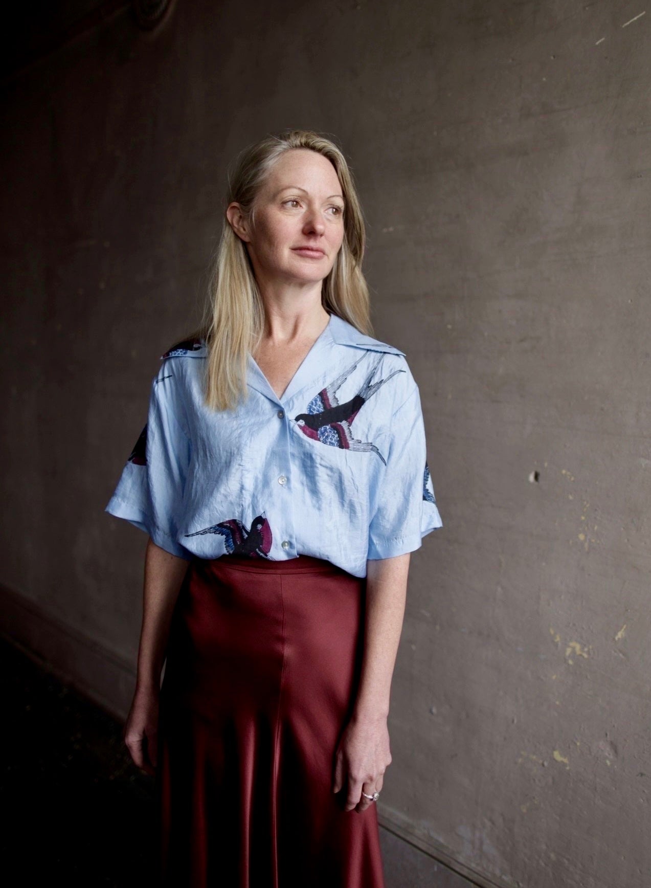 image of a woman wearing the Alix of Bohemia stevie swallow silk shirt and Forte Forte slip skirt