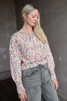 Model wearing an Alix of Bohemia colorful baby alpaca sweater and gray Veronica Beard barrel jeans 
