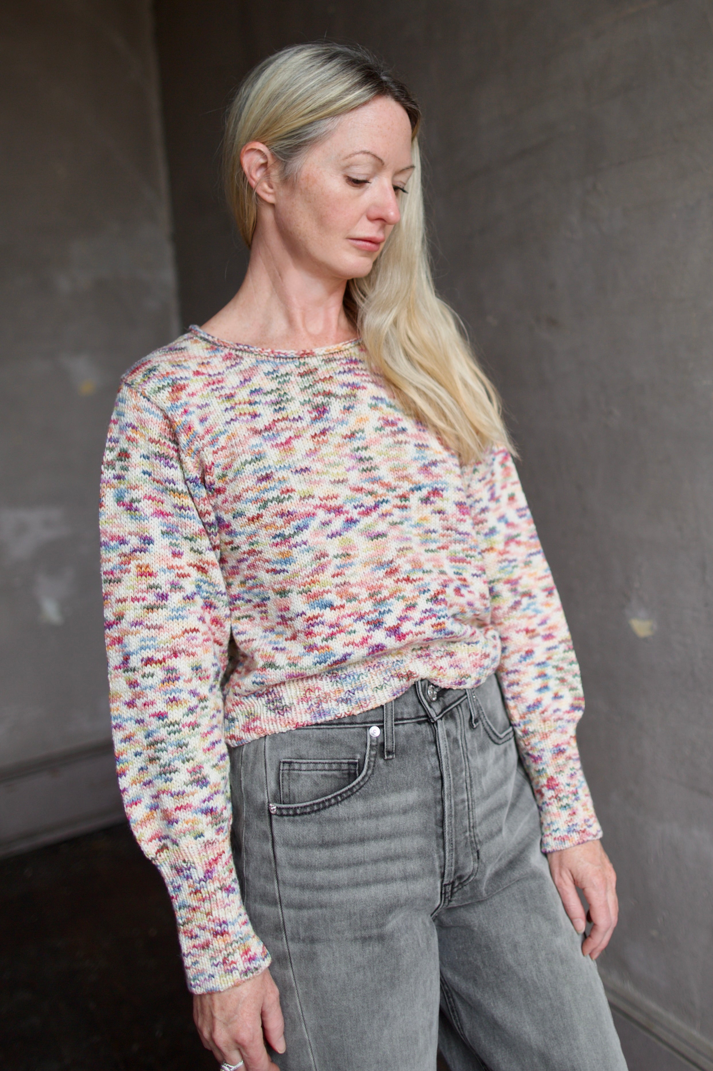 Model wearing an Alix of Bohemia colorful baby alpaca sweater and gray Veronica Beard barrel jeans 