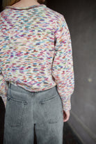 Model wearing an Alix of Bohemia colorful baby alpaca sweater and gray Veronica Beard barrel jeans 