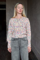 Model wearing an Alix of Bohemia colorful baby alpaca sweater and gray Veronica Beard barrel jeans 