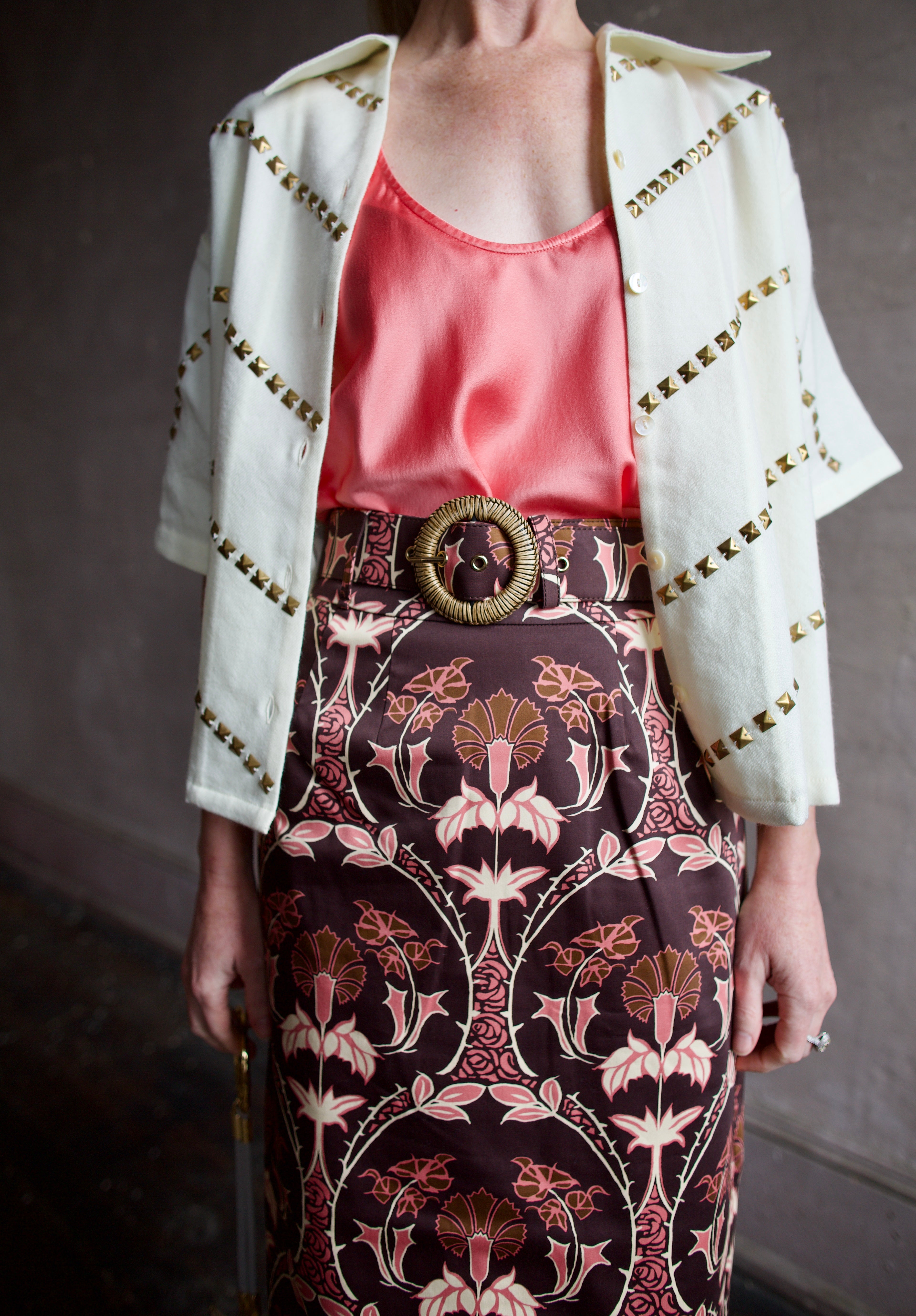 Close Up image of a woman wearing the Forte Forte Silk Tank, Alix of Bohemia Studded Top and Cara Cara Printed Skirt