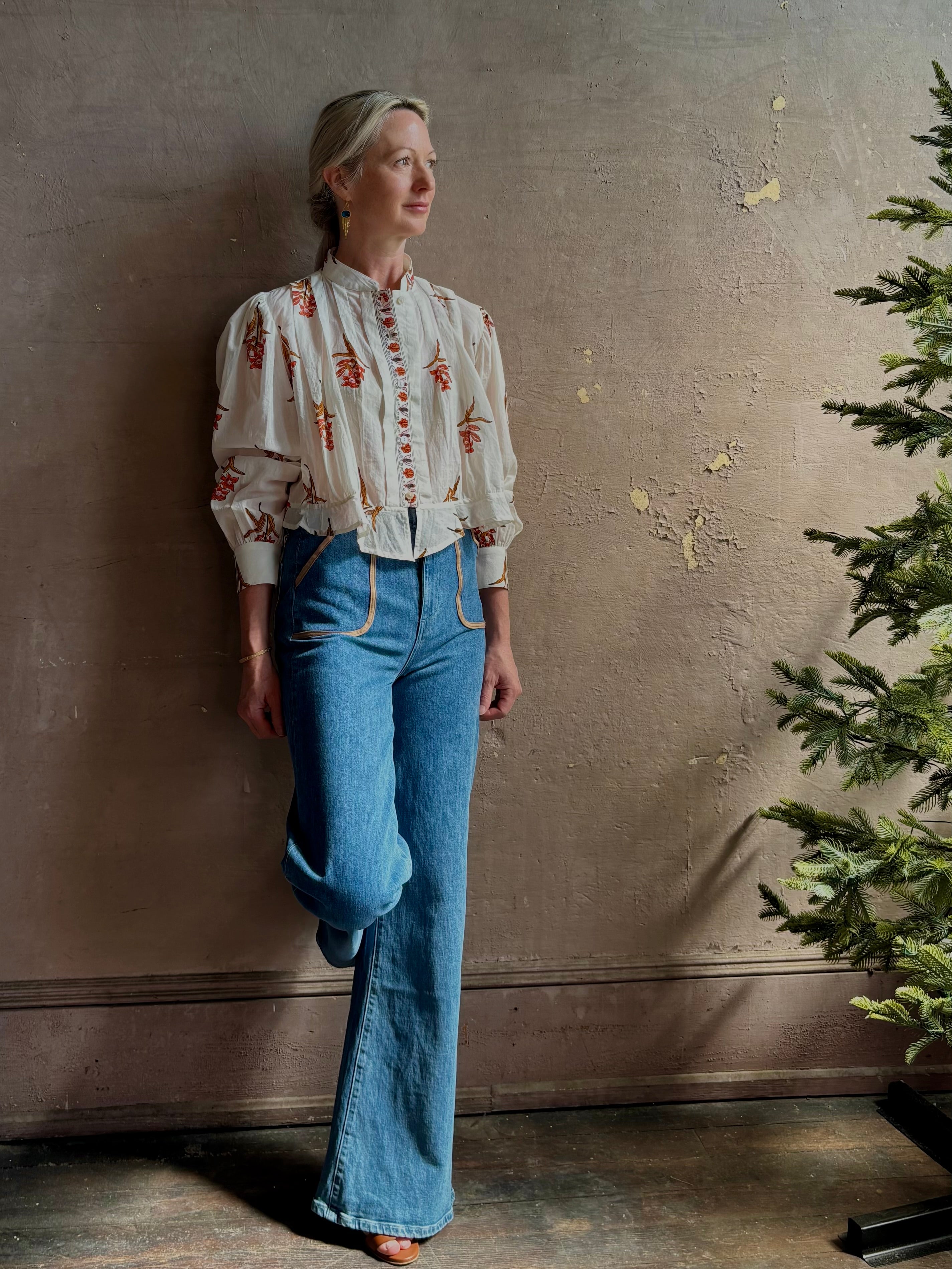 Mature woman wearing Alix of Bohemia Ryland Persimmon Flower Shirt with beautiful pin tucking and gathered waist detail at back, long sleeves, mandarin collar, and cropped top