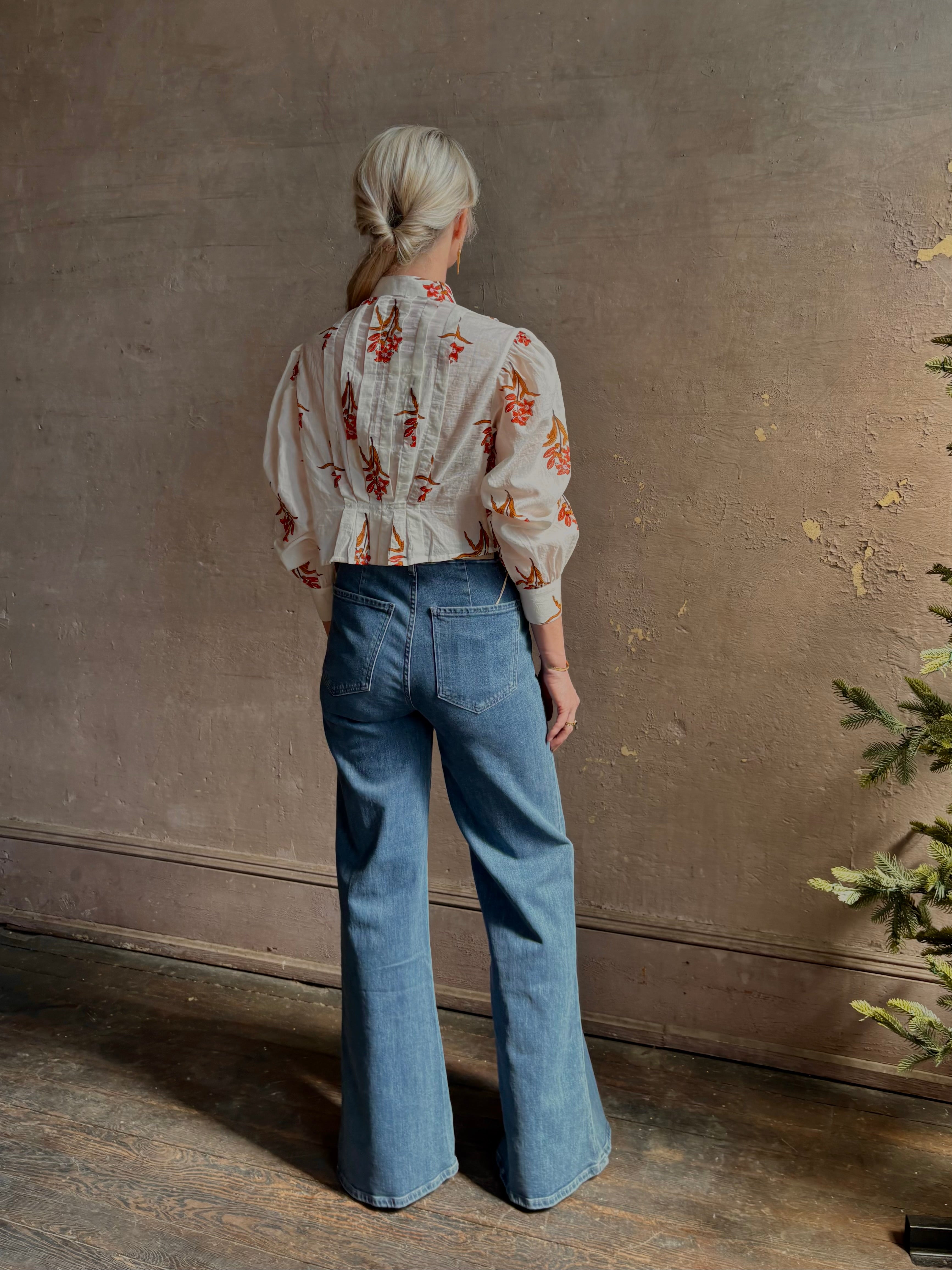 Mature woman wearing Alix of Bohemia Ryland Persimmon Flower Shirt with beautiful pin tucking and gathered waist detail at back, long sleeves, mandarin collar, and cropped top