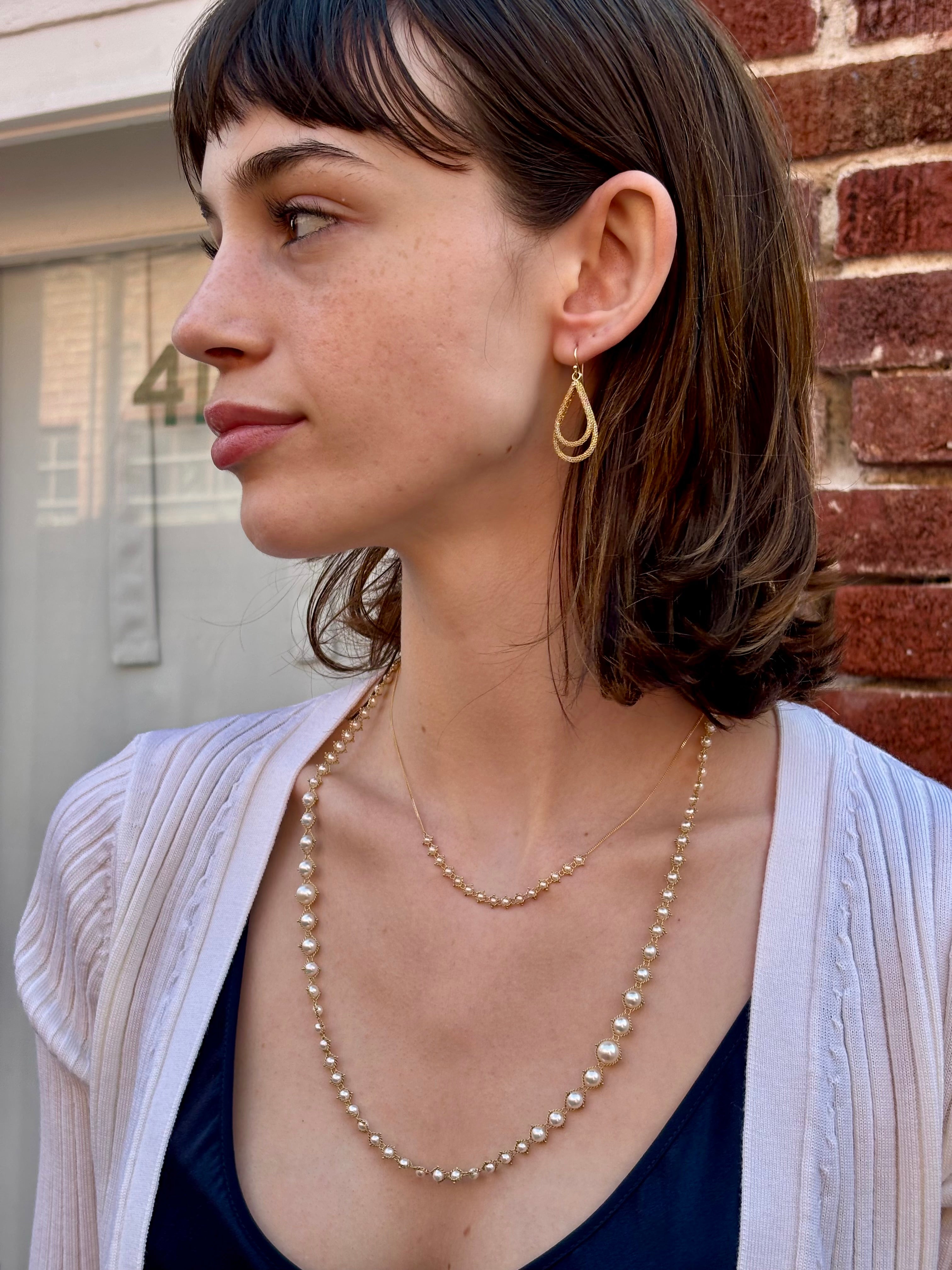 Woman wearing luxury designer Amali double Teardrop Stardust 18k yellow gold Earrings handmade in USA fine jewelry