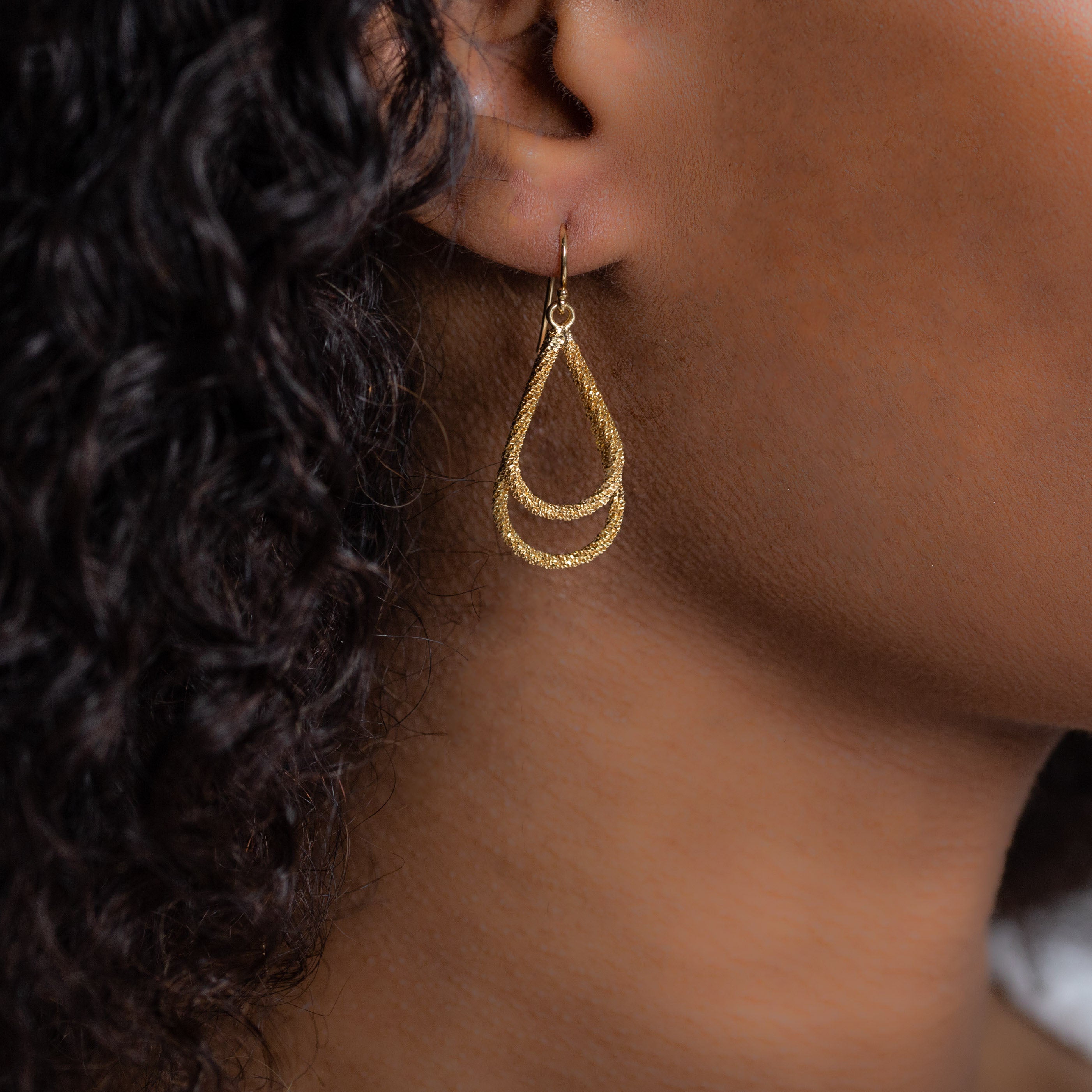 Woman wearing luxury designer Amali double Teardrop Stardust 18k yellow gold Earrings handmade in USA fine jewelry