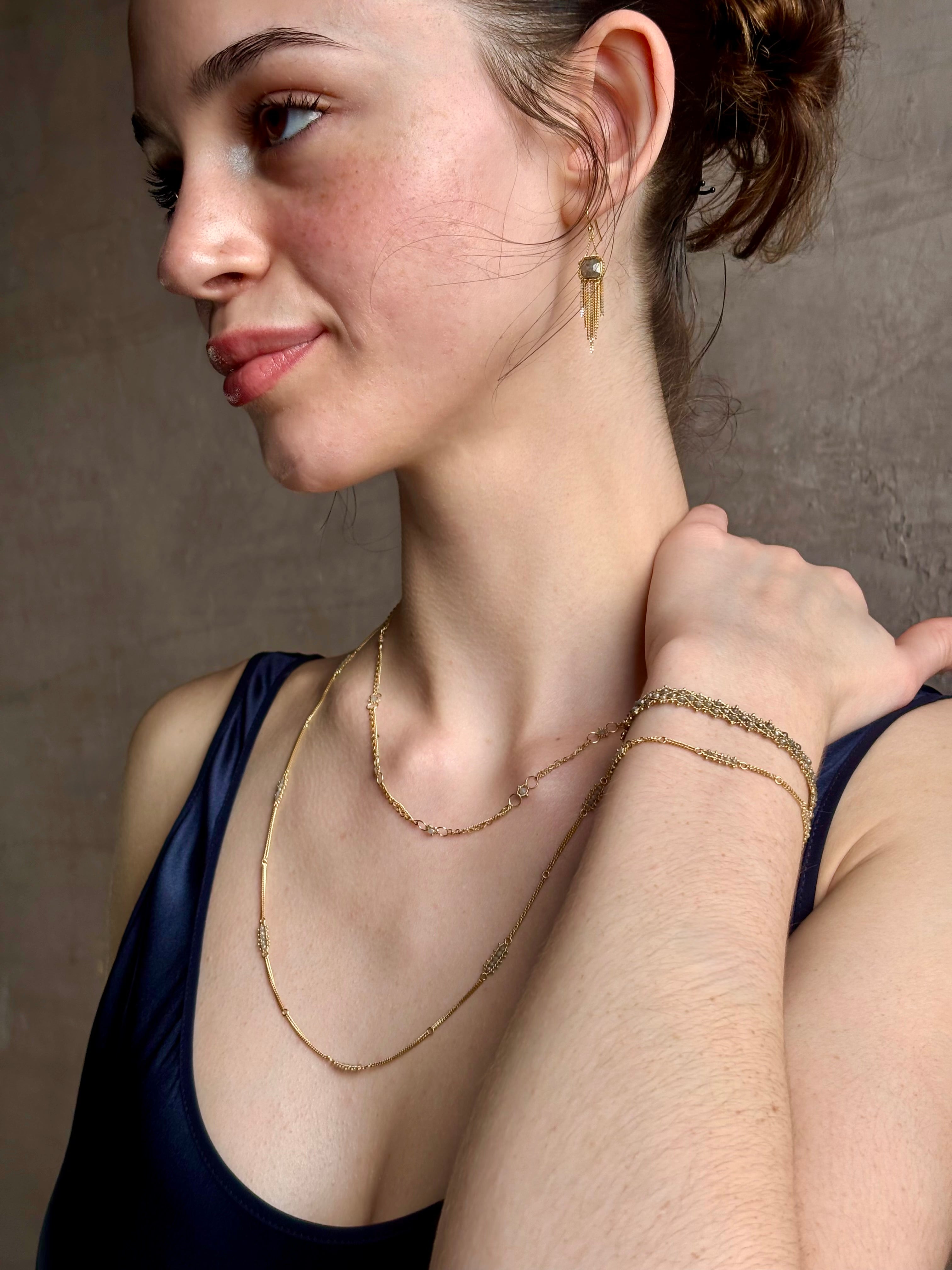 Woman wearing silver diamond and yellow gold bracelet with 5 diamond groupings all the way around by US fine jewelry designer Amali. A stylish modern take on a classic