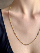 Woman wearing premium new york fine jewelery designer Amali Silver Diamonds and 18K yellow Gold with clusters of five diamonds between chain lengths in a sleek 21st century design