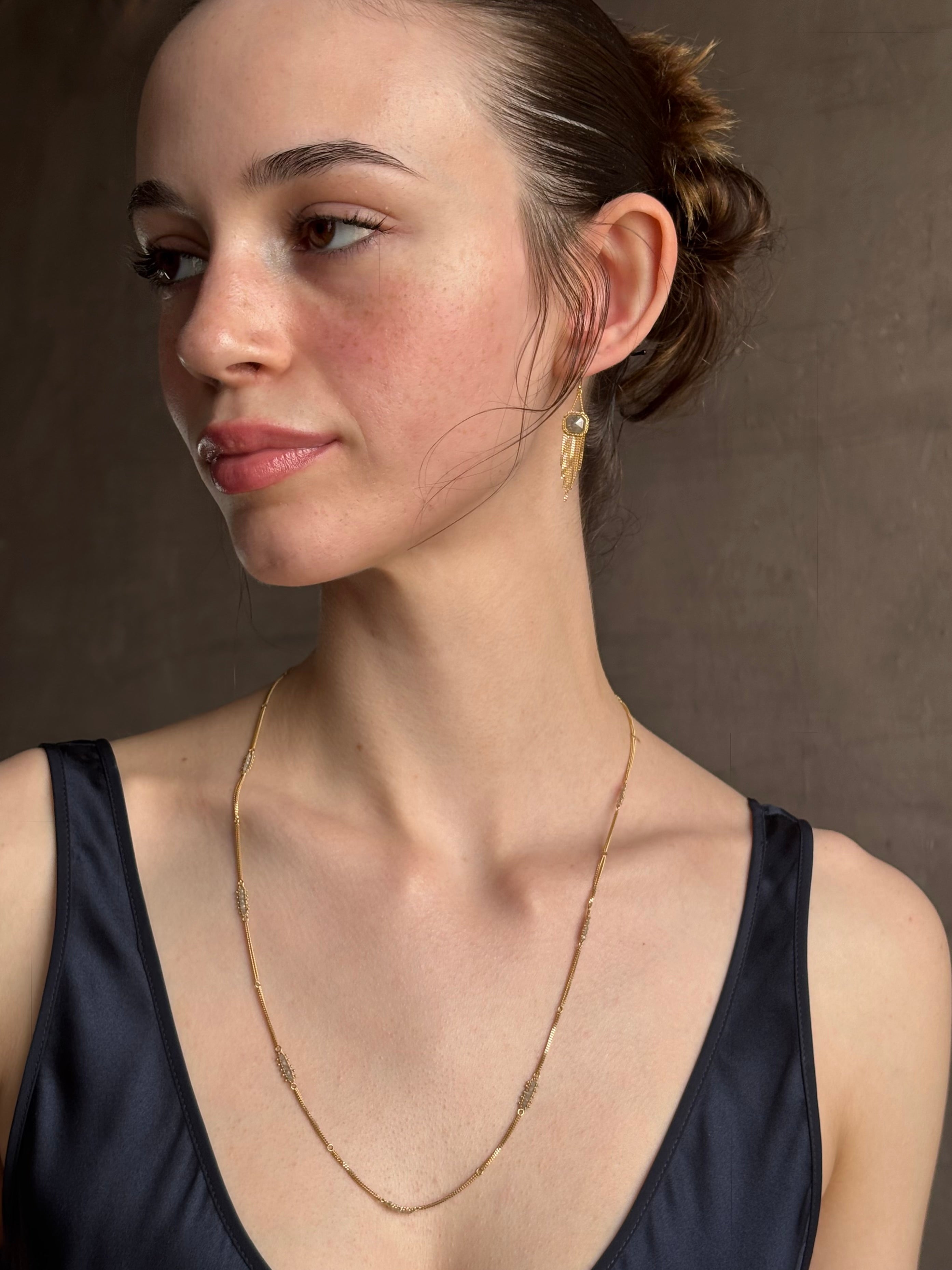 Woman wearing premium new york fine jewelery designer Amali Silver Diamonds and 18K yellow Gold with clusters of five diamonds between chain lengths in a sleek 21st century design