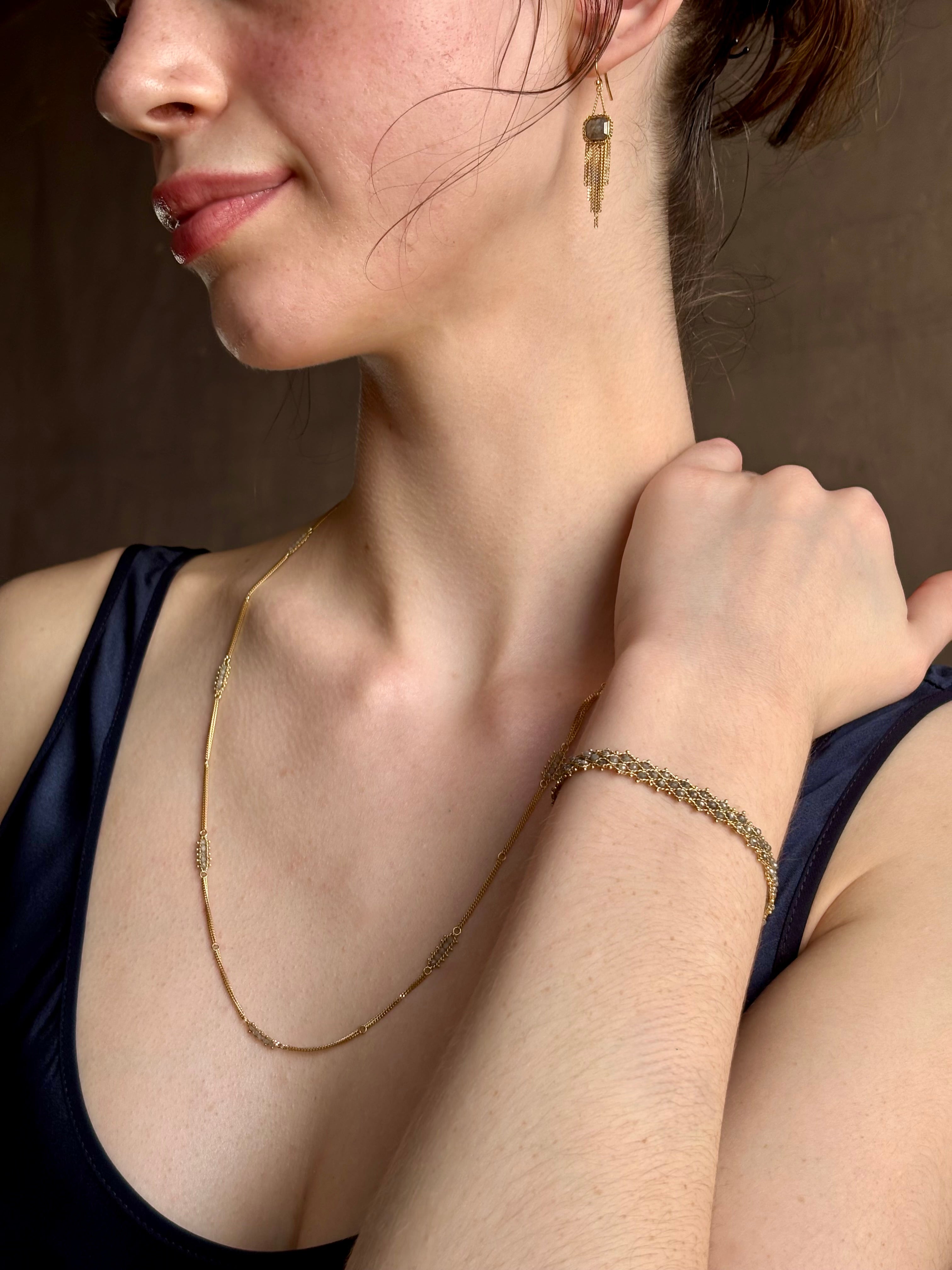 Woman wearing premium new york fine jewelery designer Amali Silver Diamonds and 18K yellow Gold with clusters of five diamonds between chain lengths in a sleek 21st century design