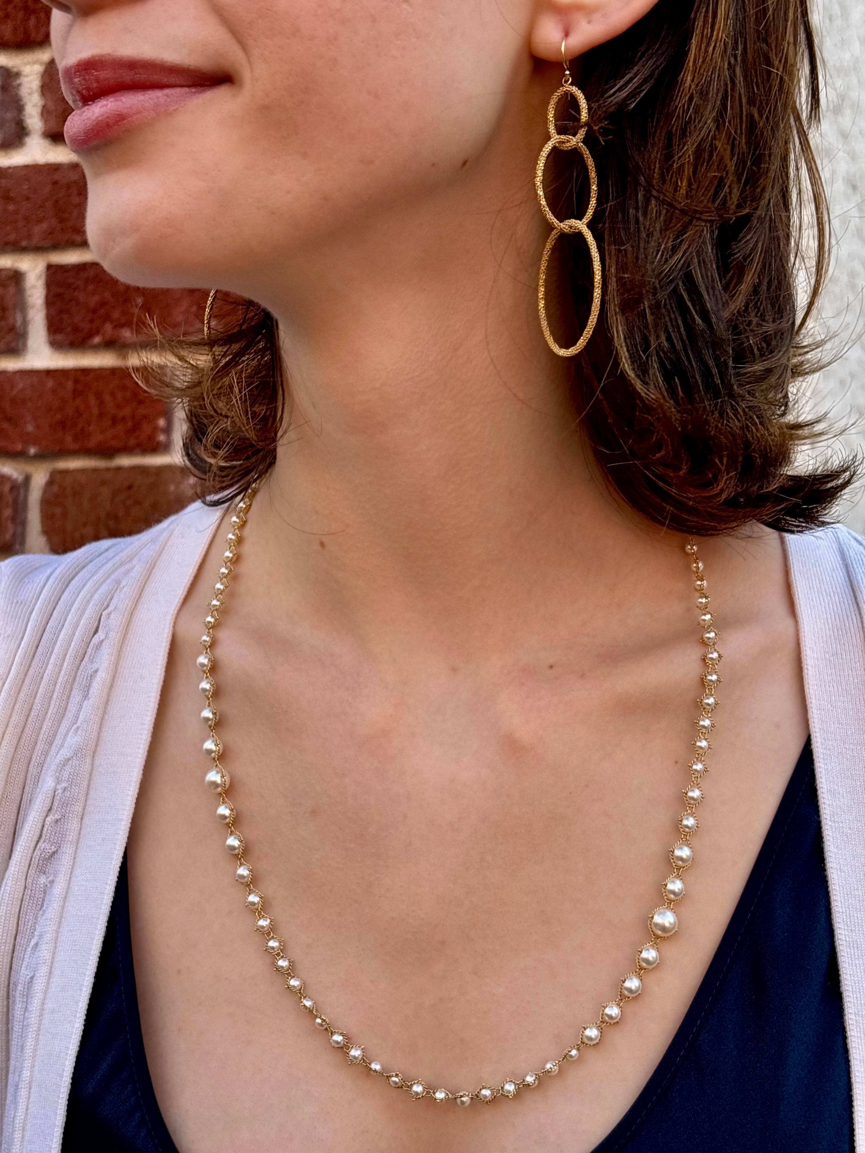 Image of a woman wearing fine jewelry Amali Triple Oval Stardust 18k yellow gold designer Earrings handmade in USA