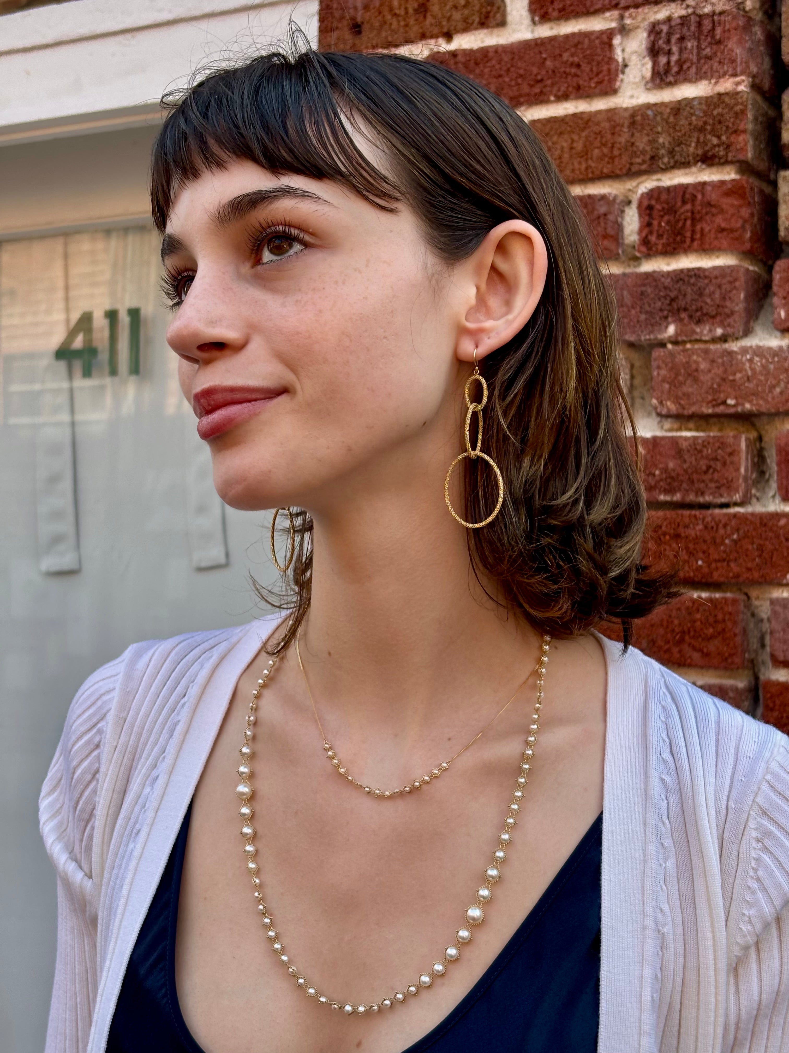 Woman wearing fine jewelry Amali Triple Oval Stardust 18k yellow gold designer Earrings handmade in USA