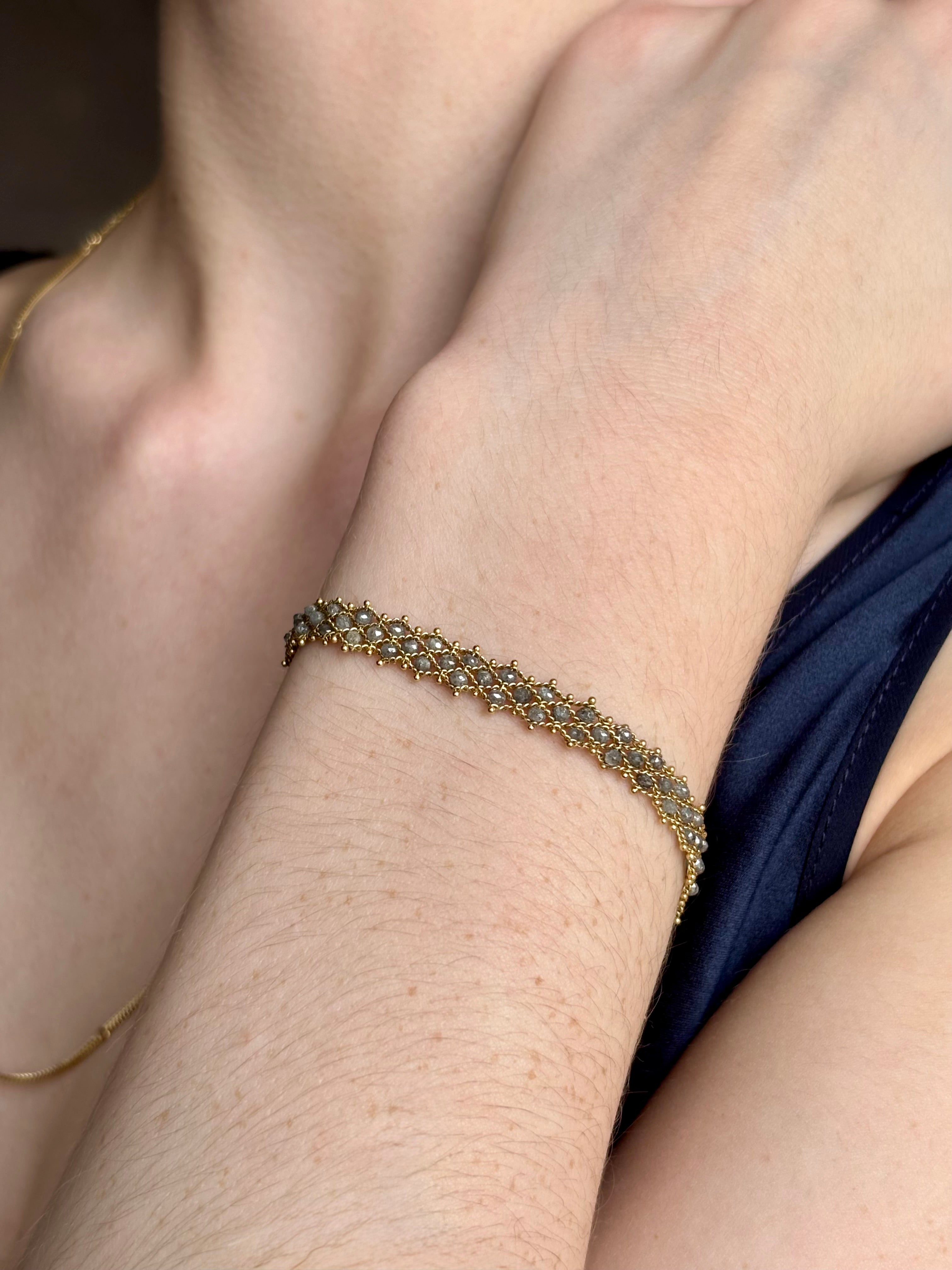 Woman wearing premium New York fine jewelry designer Amali Woven Bracelet in Grey Diamonds and 18K Gold in a sleek modern design