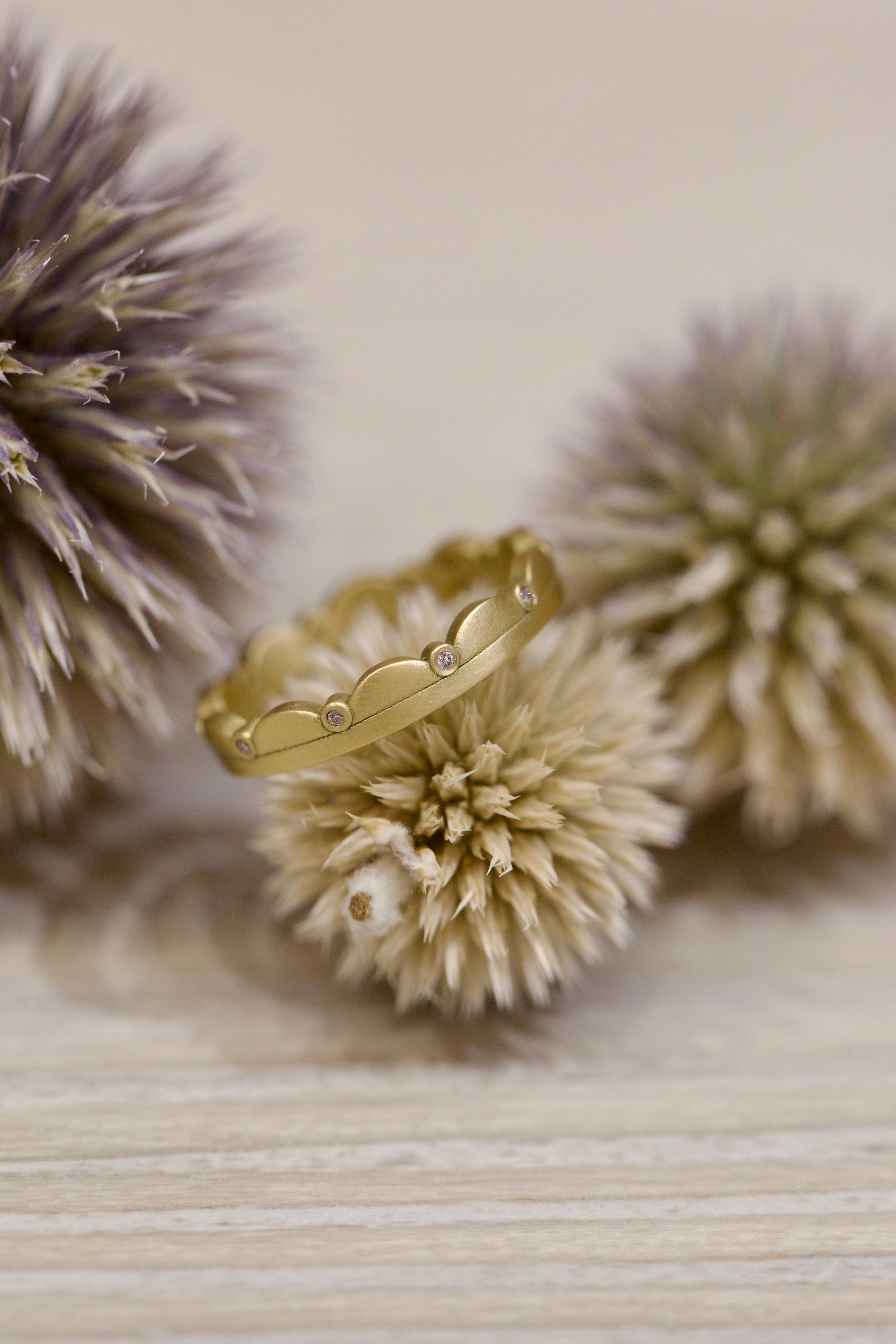 Image of American Jeweler Ananda Khalsa handmade 18k hammered matte gold band with encircling scalloped design and inset white diamonds