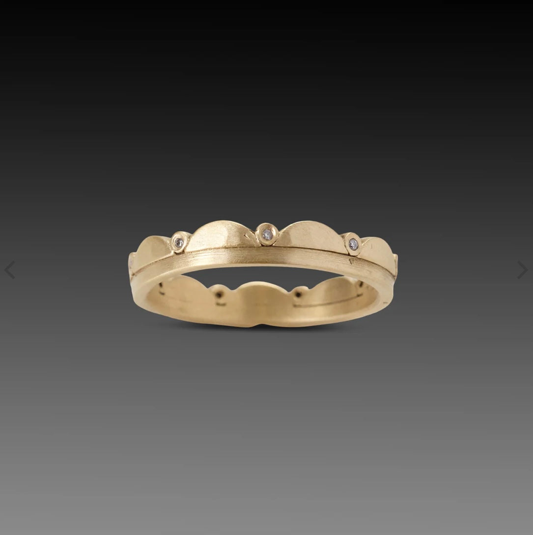 Image of a 18k gold band encircled with gentle scallops, punctuated by sparkling inset diamonds. This ring stacks with others beautifully. Band measures 3.5mm at widest point.