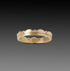 Image of a 18k gold band encircled with gentle scallops, punctuated by sparkling inset diamonds. This ring stacks with others beautifully. Band measures 3.5mm at widest point.