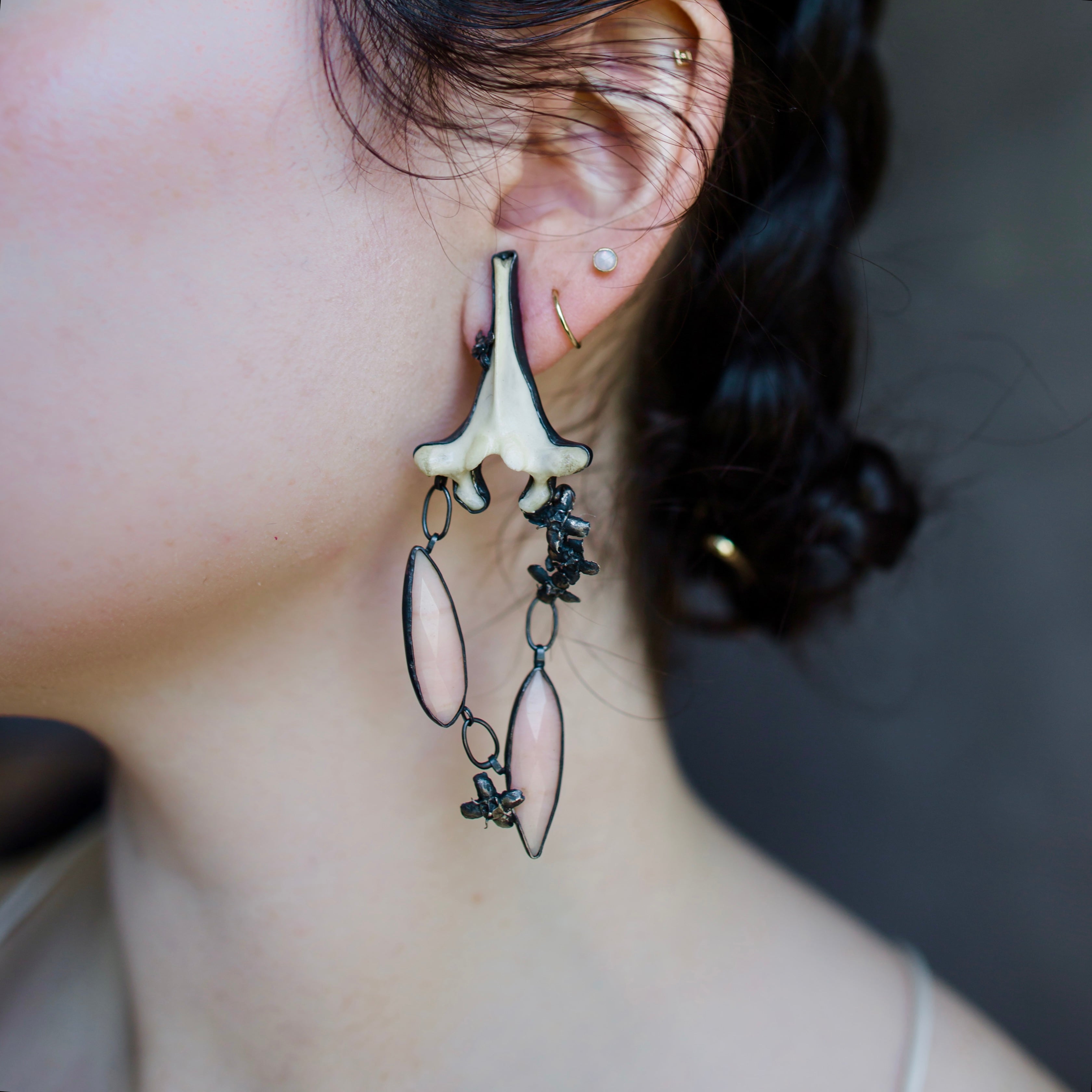 Image featuring a woman wearing North Carolina artist and jeweler Anna Johnson Hearts a Bustin vertebral Earrings