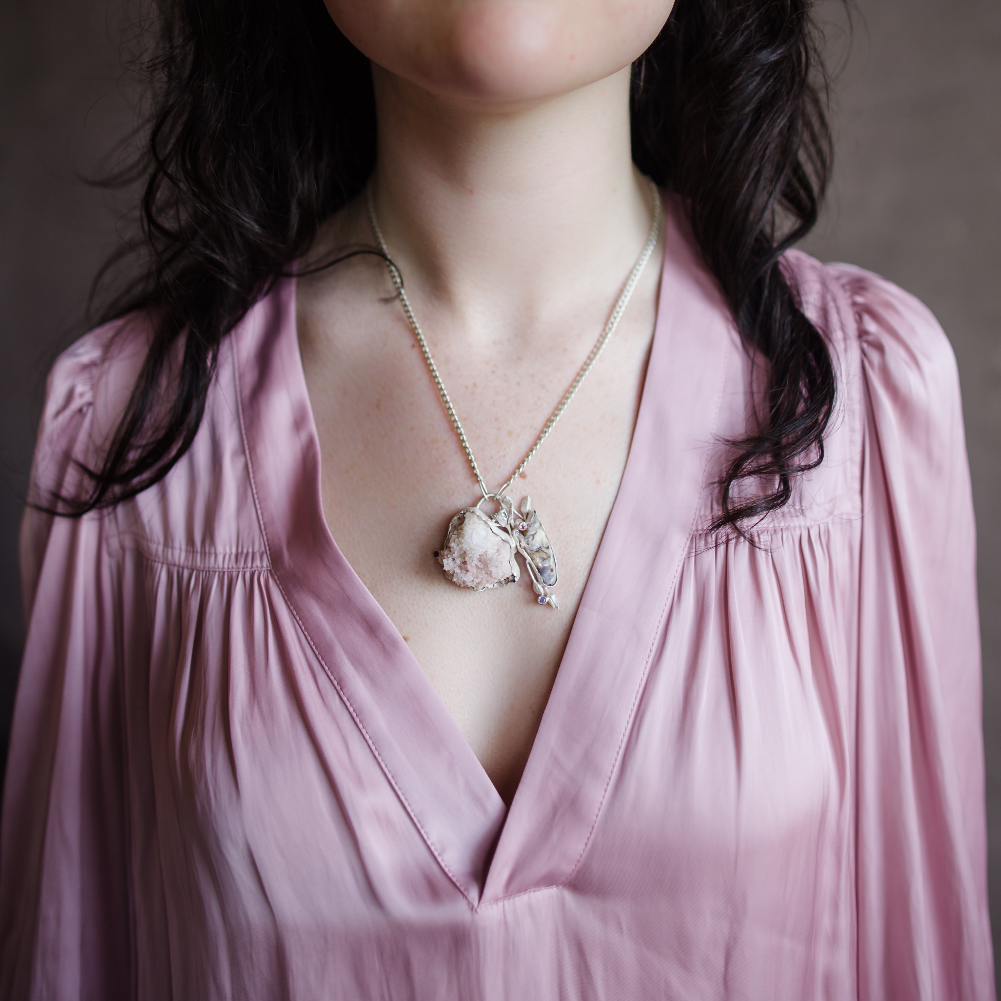 Image featuring a woman wearing North Carolina artist Anna Johnson skull Necklace with Rat skull, zeolite, opalescent rubies, depletion gilded silver and cast garlic chive flowers