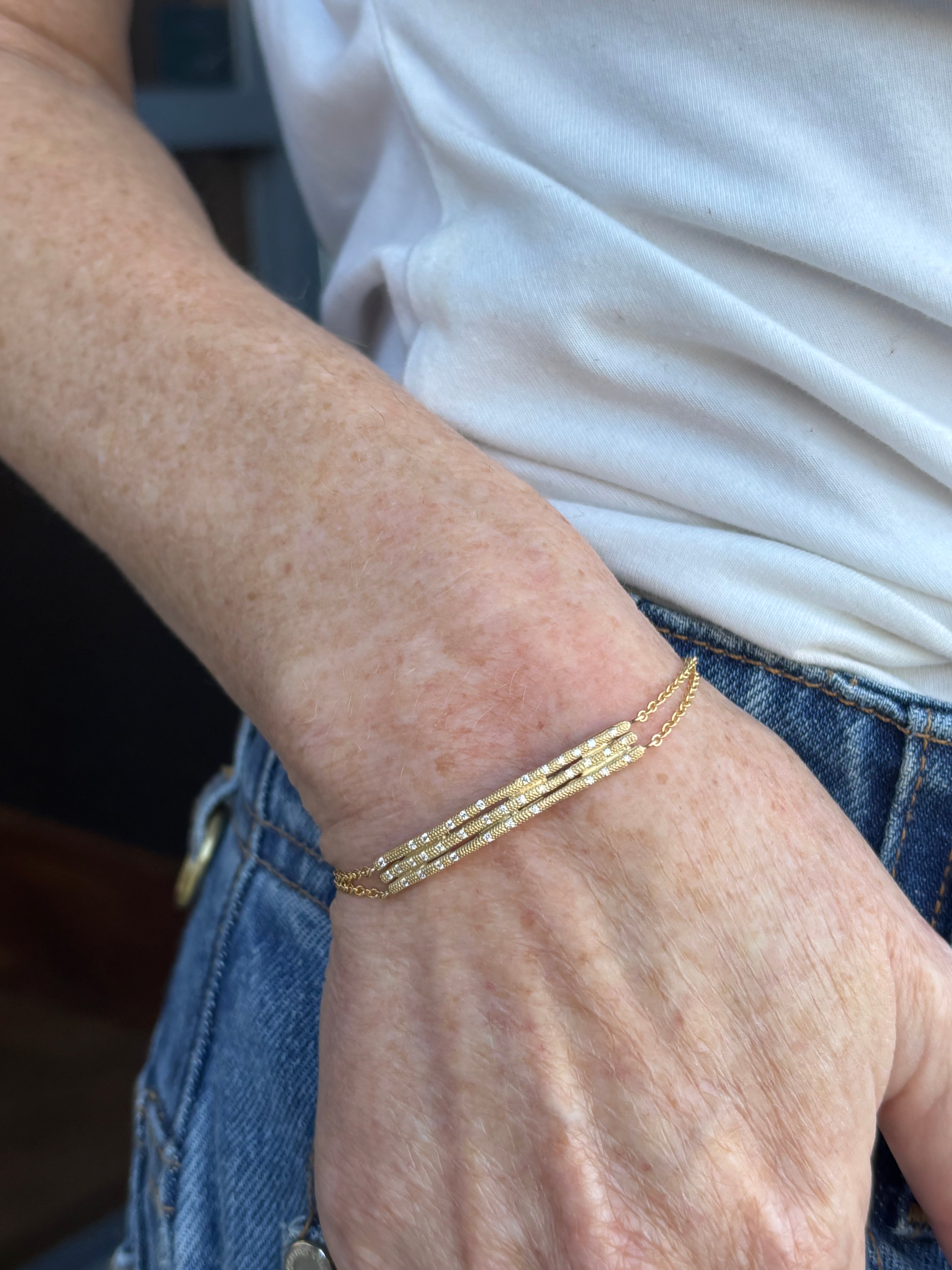 Image of woman wearing fine jewelry designer ANNE SPORTUN Stardust Triple Stick Bracelet in 18K Yellow Gold and Diamonds with an adjustable clasp
