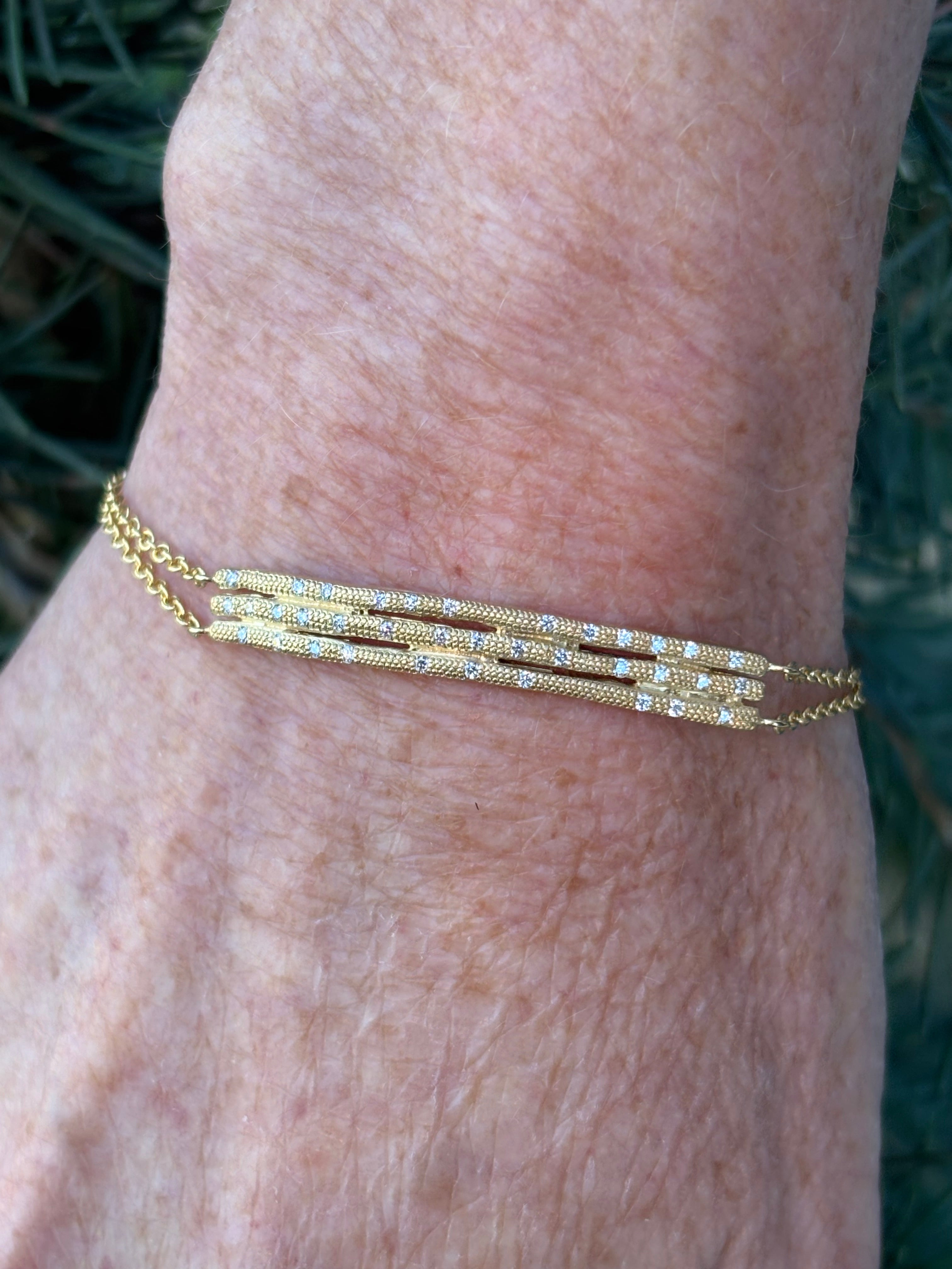 Image of woman wearing fine jewelry designer ANNE SPORTUN Stardust Triple Stick Bracelet in 18K Yellow Gold and Diamonds with an adjustable clasp