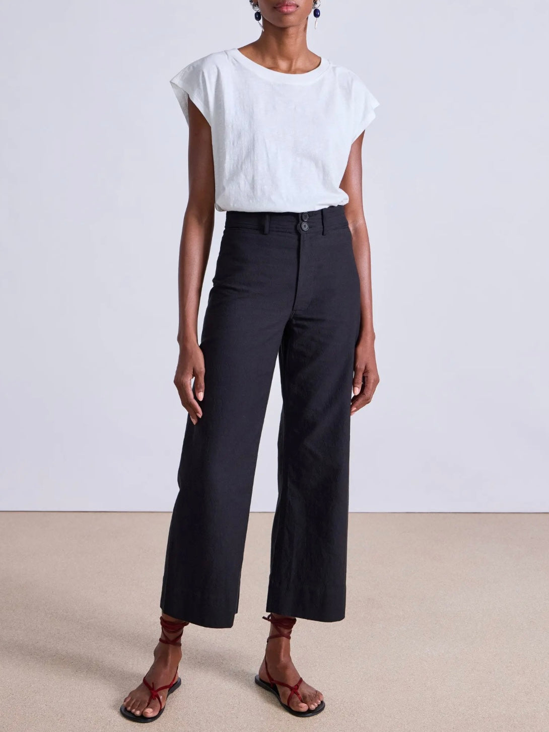 Model wearing expertly tailored Apiece Apart Merida high rise black pants with belt loops and front zip