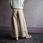 Image featuring a woman wearing the Apiece Apart Malou pants in organic cotton twill with a high-rise, flat front, side slant pockets, back welt pockets, cropped wide leg.