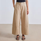 Image featuring a woman wearing the Apiece Apart Malou pants in organic cotton twill with a high-rise, flat front, side slant pockets, back welt pockets, cropped wide leg.