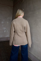 Image of the back of a woman wearing the Apiece Apart Paris V-Neck cardigan and Re/Done wide leg crop jeans.