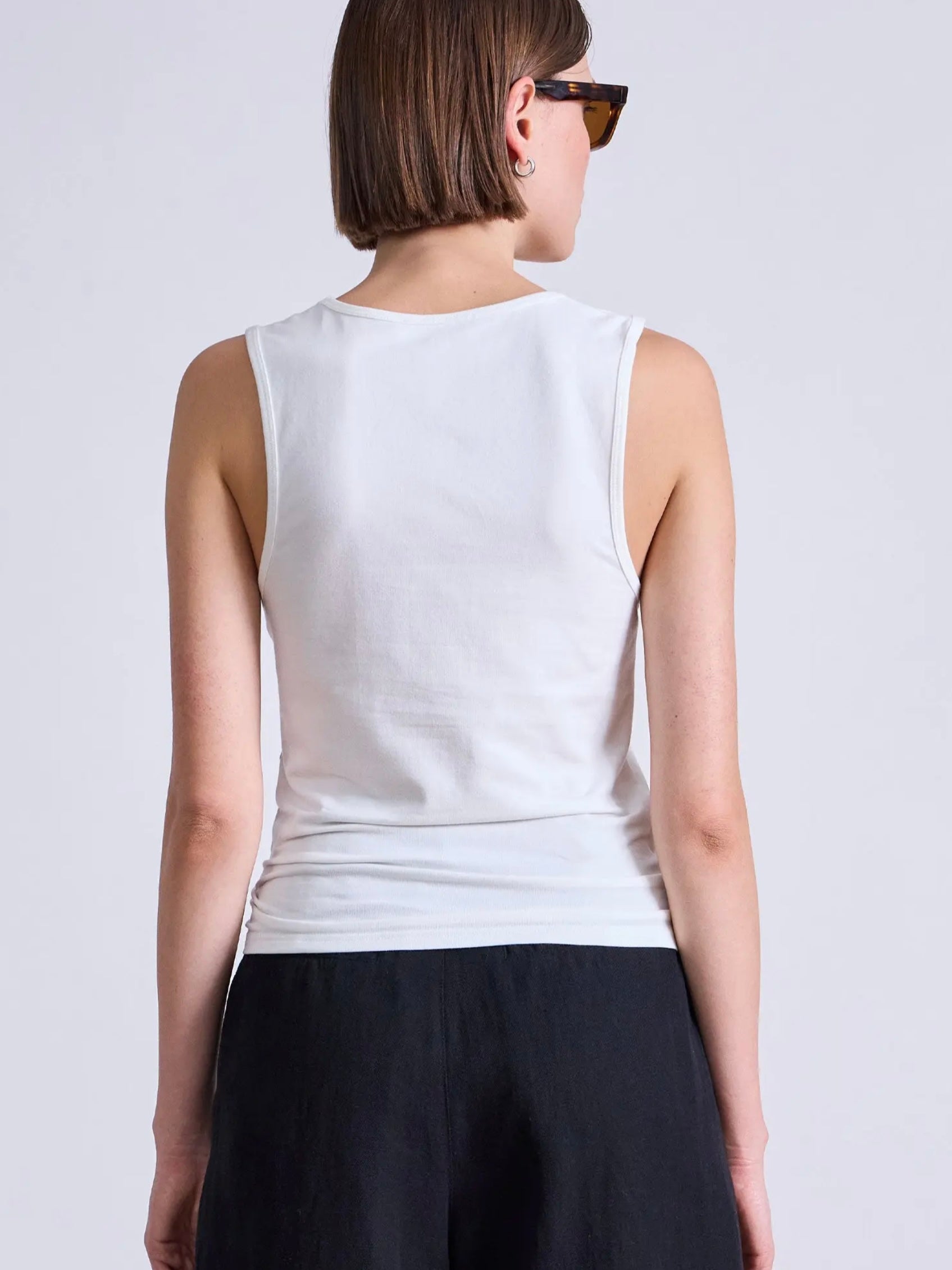Model wearing a white cotton tank top with bra friendly back from Apiece Apart