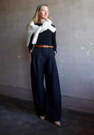 image of woman wearing the Apiece Apart merino ribbed sweater and mirabelle trousers with the Ulla Johnson gia belt and Naadam Luxe cardigan