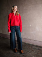 Image featuring a woman wearing the red cotton sweater by Apiece Apart with a split neckline, collar and back seam detailing in a relaxed fit.