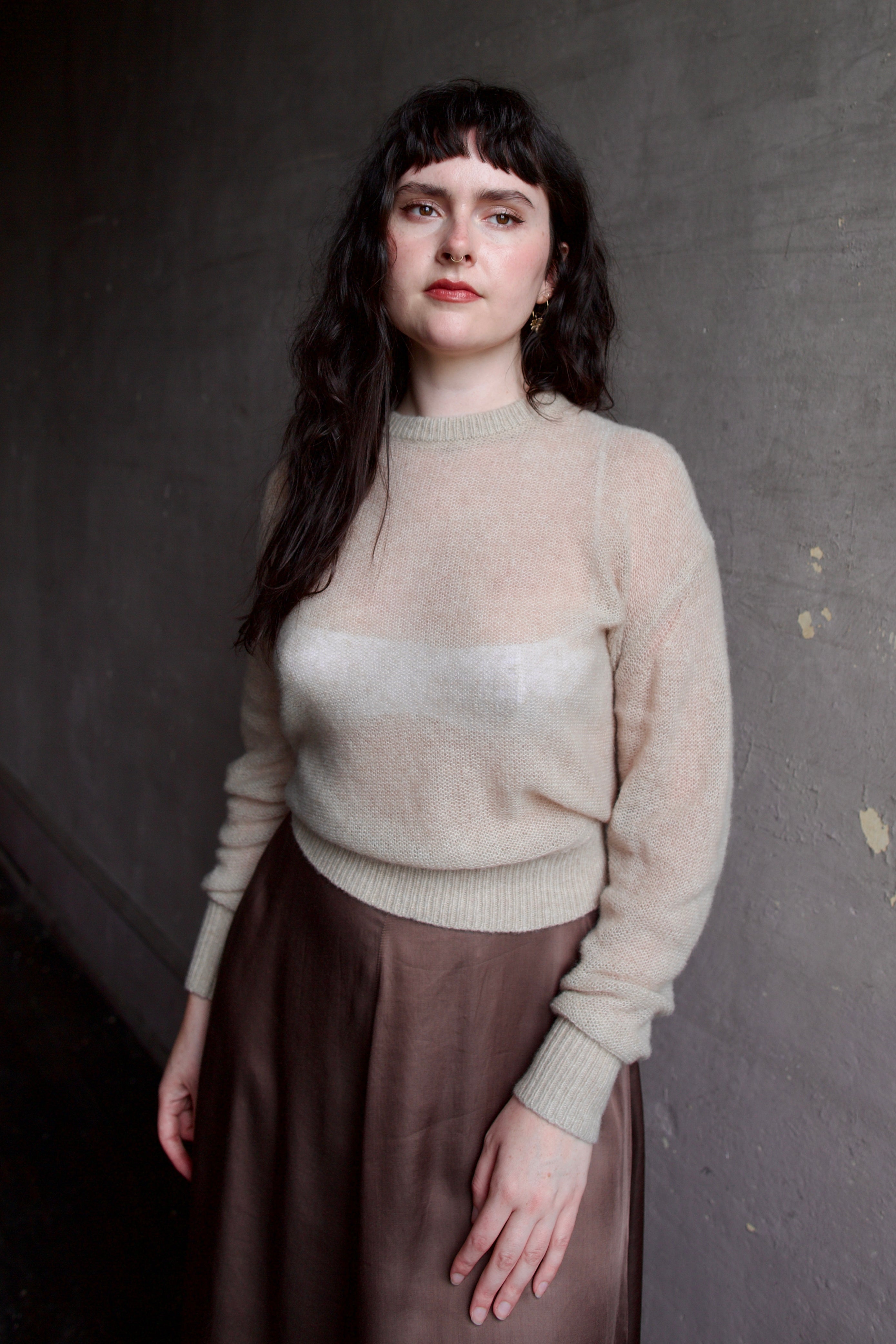 Model wearing Apiece Apart cashmere silk beige tissue weight sweater and brown skirt 