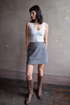 Model wearing Apiece Apart Marta mini skirt in sophisticated neutral heathered grey in virgin wool
