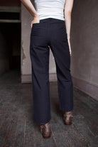 Model wearing expertly tailored Apiece Apart Merida black pants with belt loops and back pockets