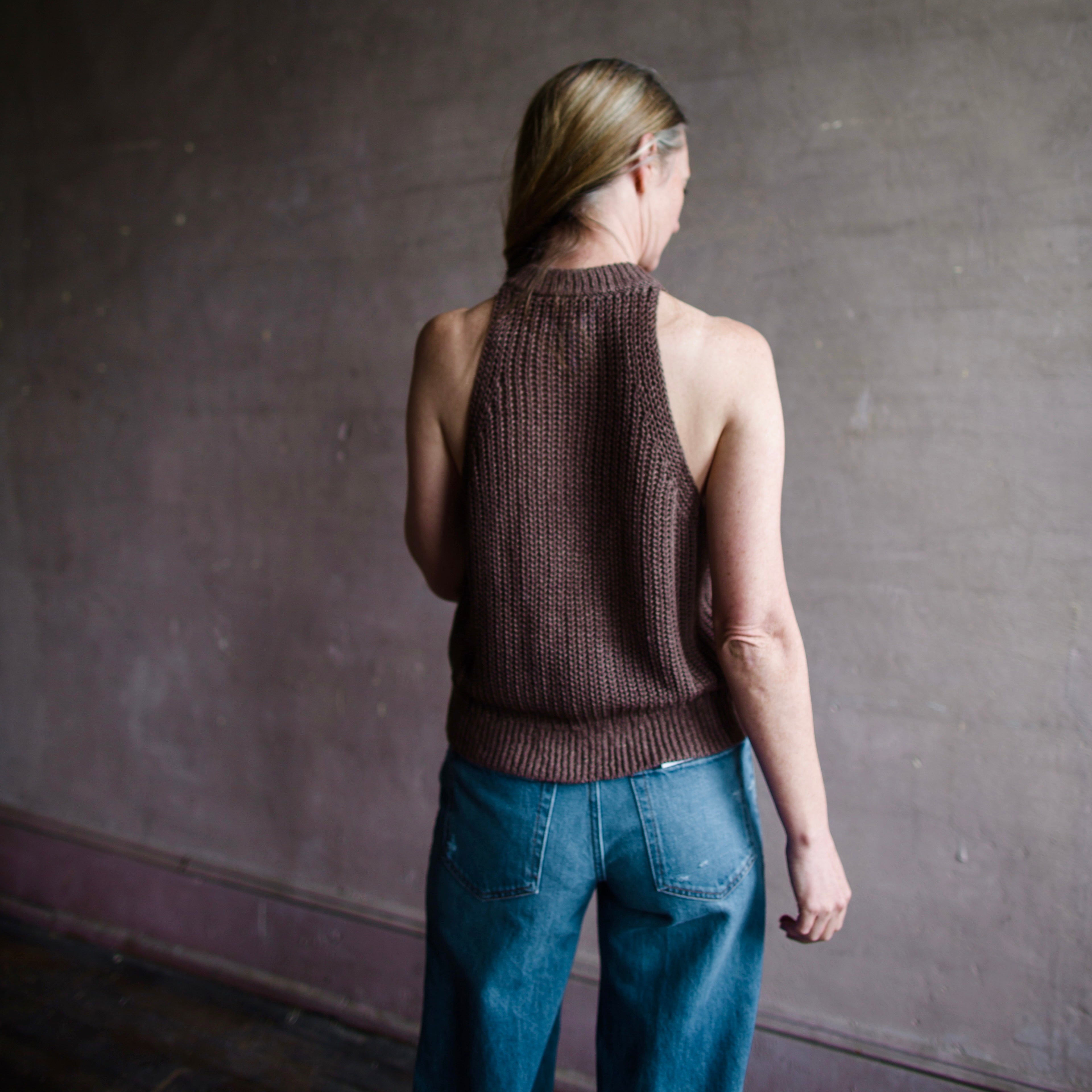 Image featuring a woman wearing the Apiece Apart Ori linen sweater is an easy sweater featuring a racerback and ribbed details throughout.