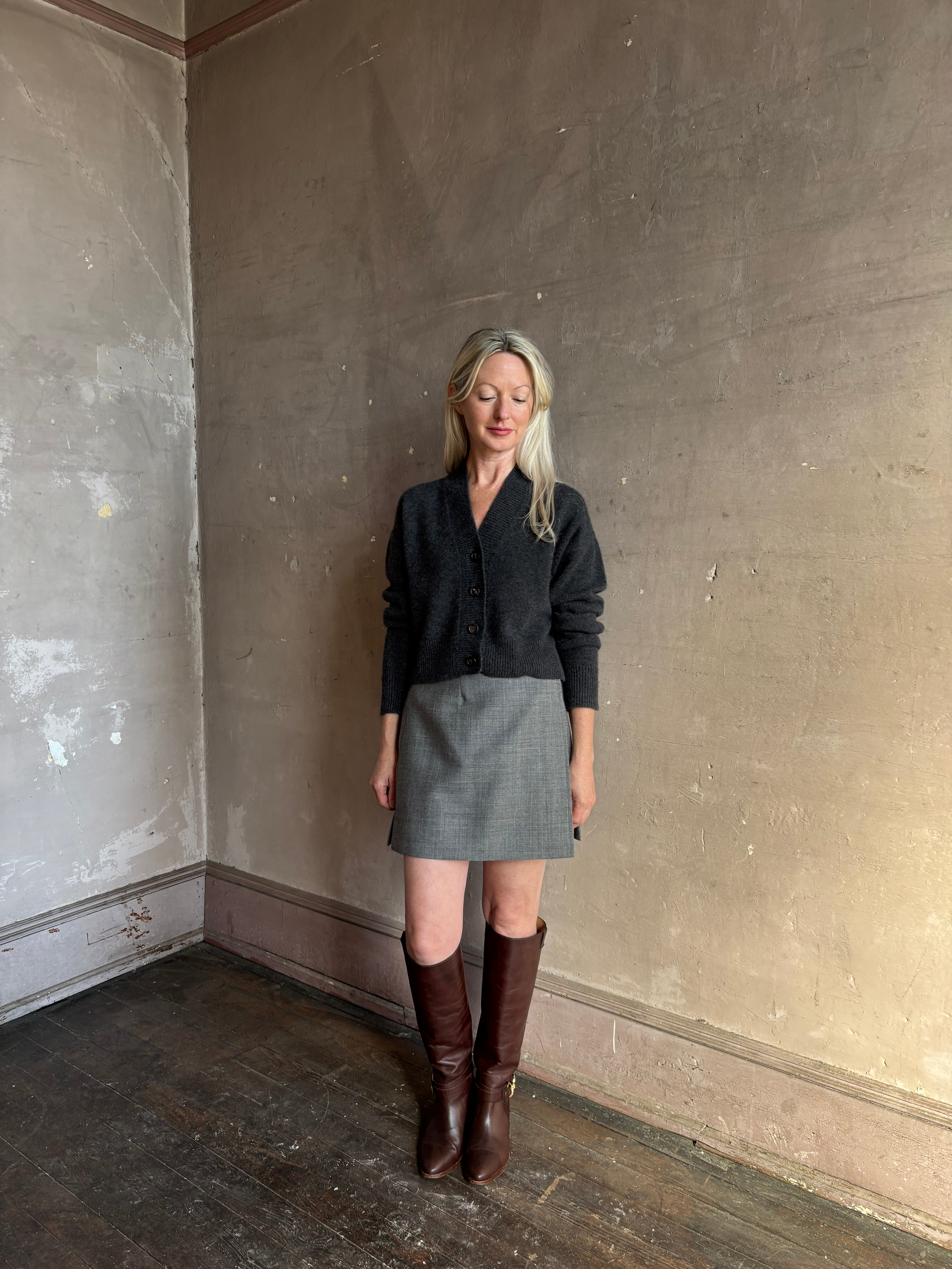 Mature woman wearing Apiece Apart Marta mini skirt in sophisticated neutral heathered grey virgin wool