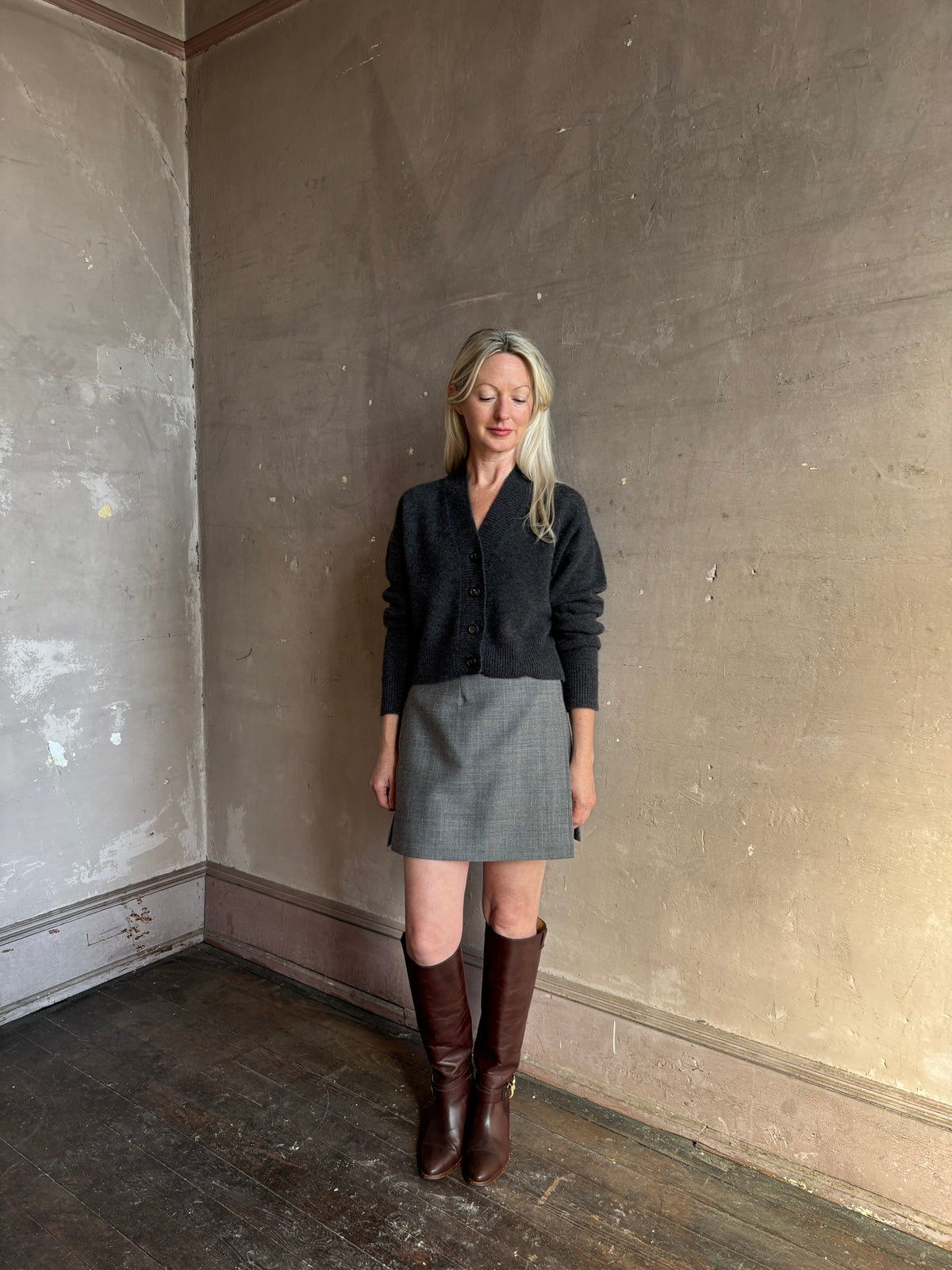 Mature woman wearing Apiece Apart Marta mini skirt in sophisticated neutral heathered grey virgin wool